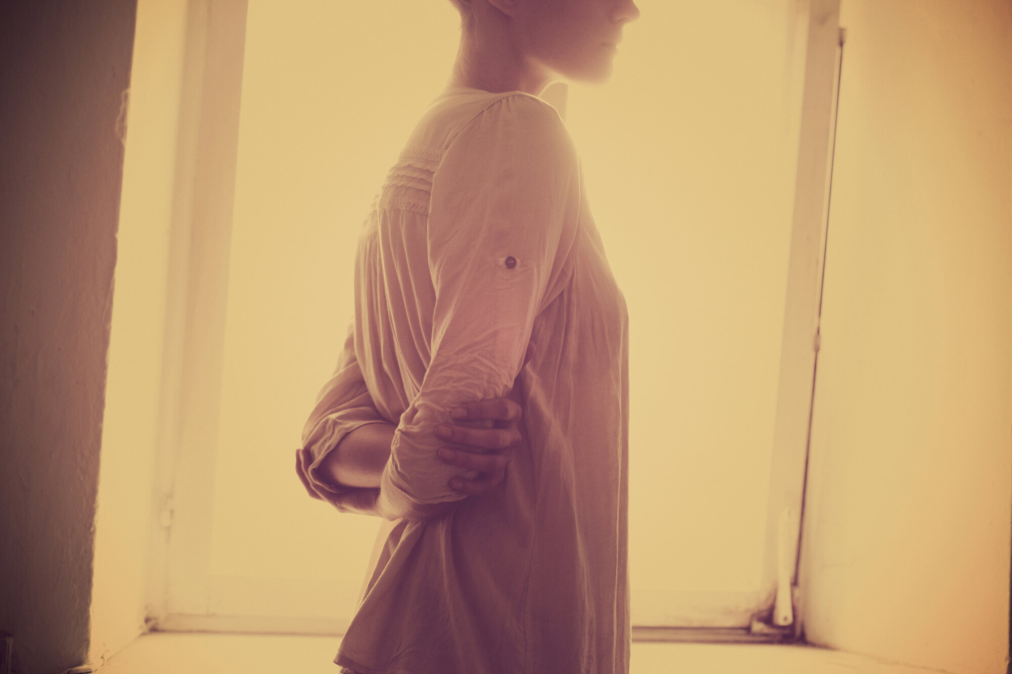 Kvinne står ved vindu Kvinne står ved vindu