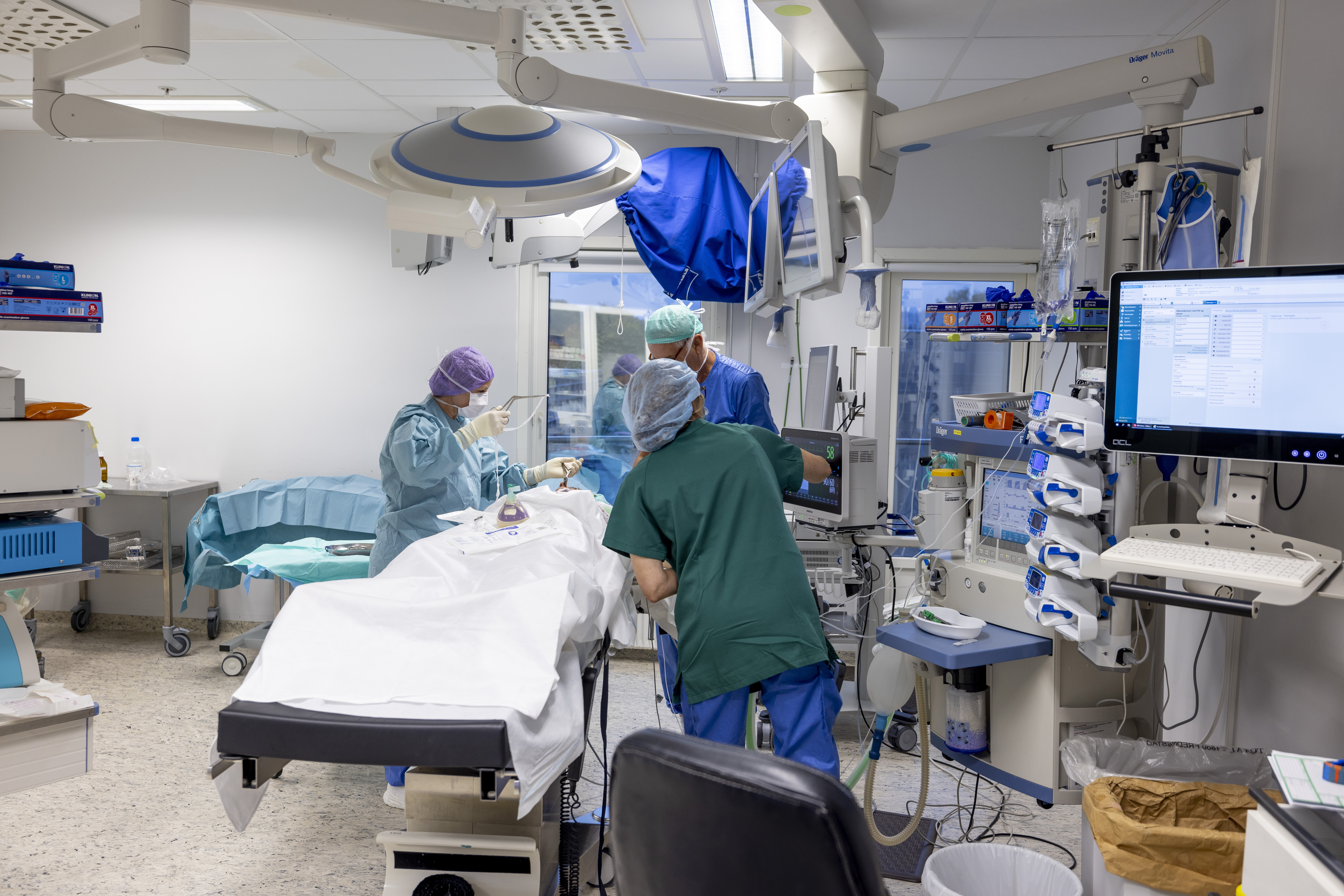 Sykepleiere som gjør klar en operasjonsstue. Bildet viser sykepleiere som gjør klar en operasjonsstue.