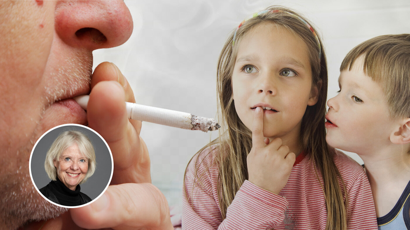 En som røyker foran to små barn Bildet viser en som røyker foran to små barn