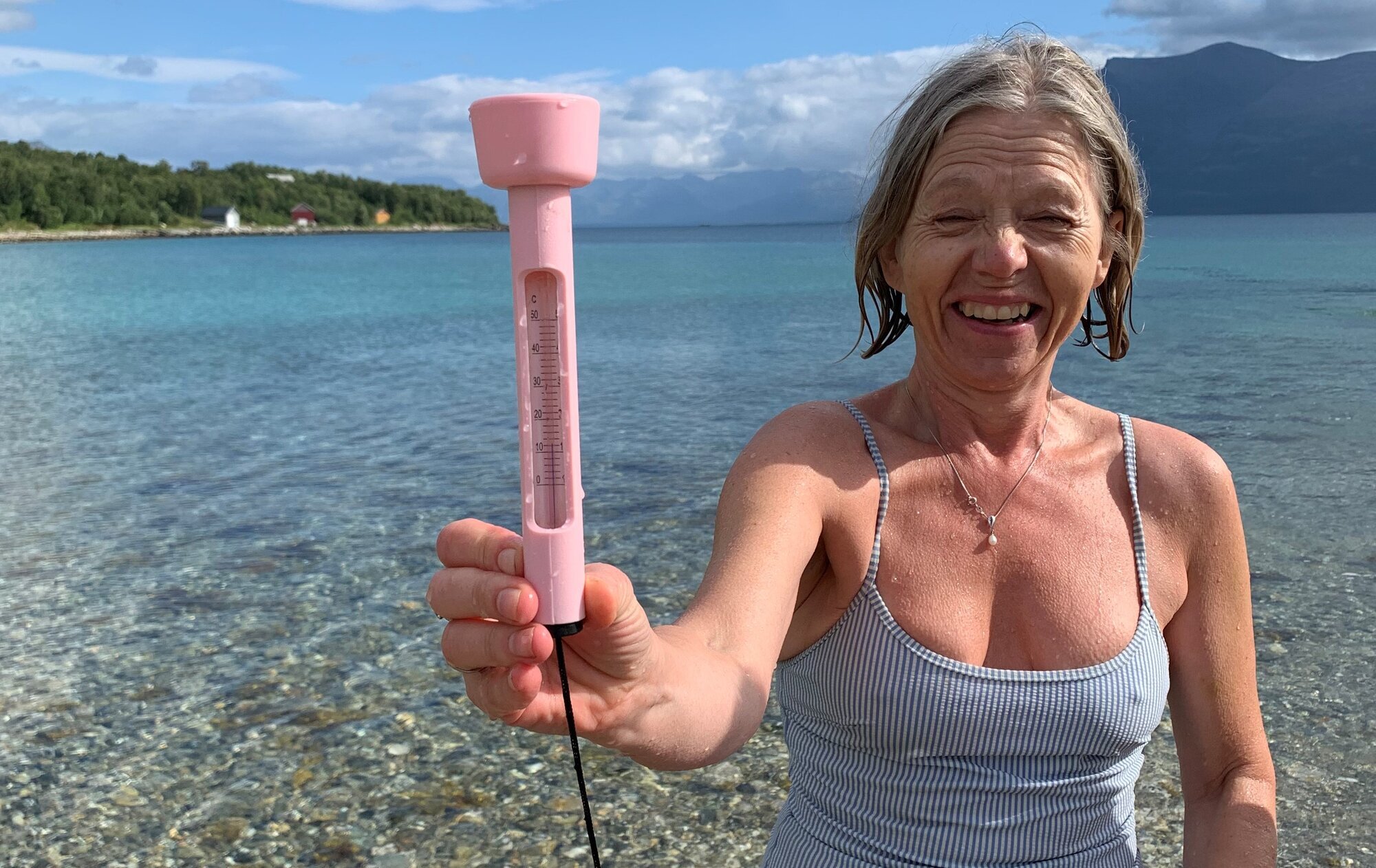 Bildet viser Torill Schneider Aarøen som isbader og holder opp et termometer Bildet viser Torill Schneider Aarøen som isbader og holder opp et termometer
