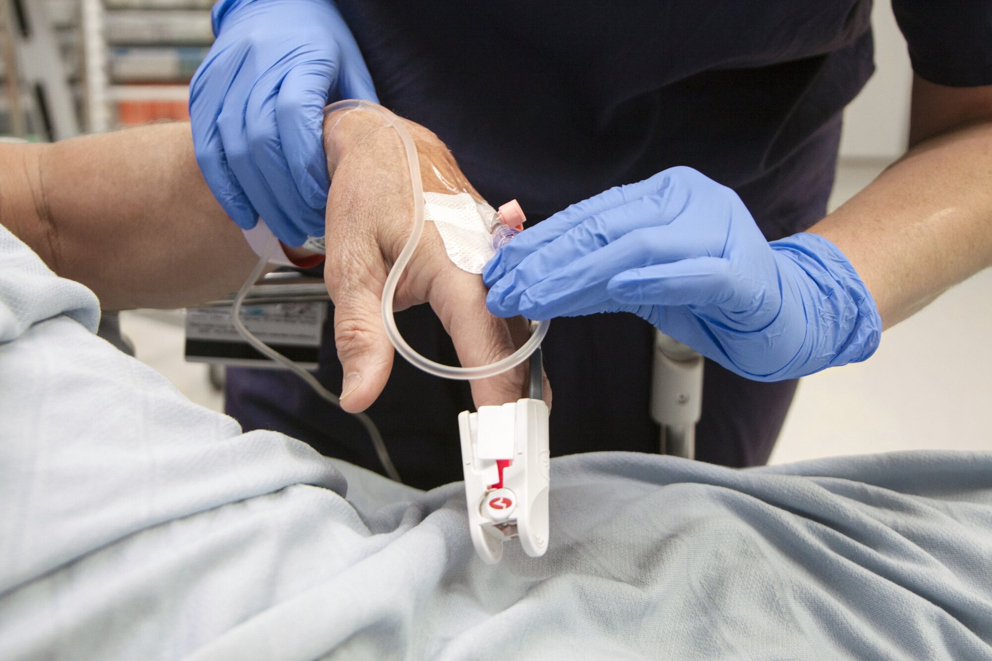 Perifert venekateter Bildet viser hender som steller et perifert venekateter.