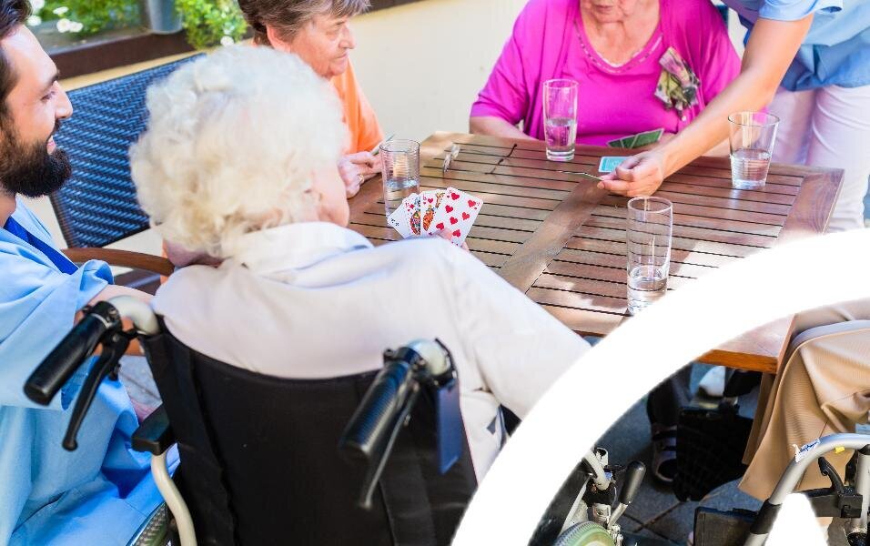 Bildet viser sykehjemsbeboere som spiller kort ute Bildet viser sykehjemsbeboere som spiller kort ute