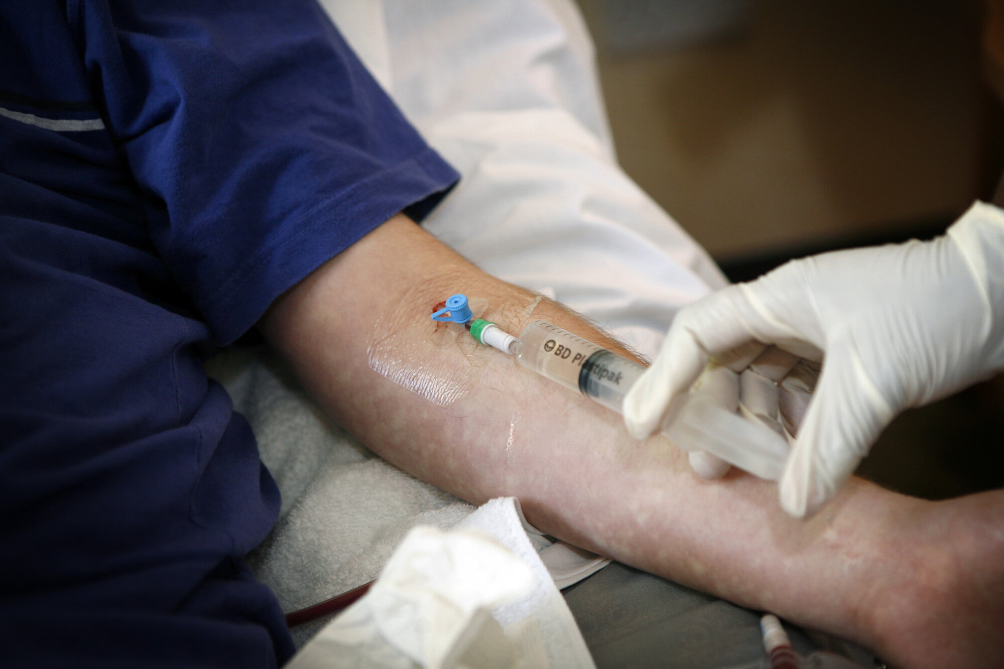 Bildet viser en sykepleier som gir intravenøs antibiotika til en pasient.