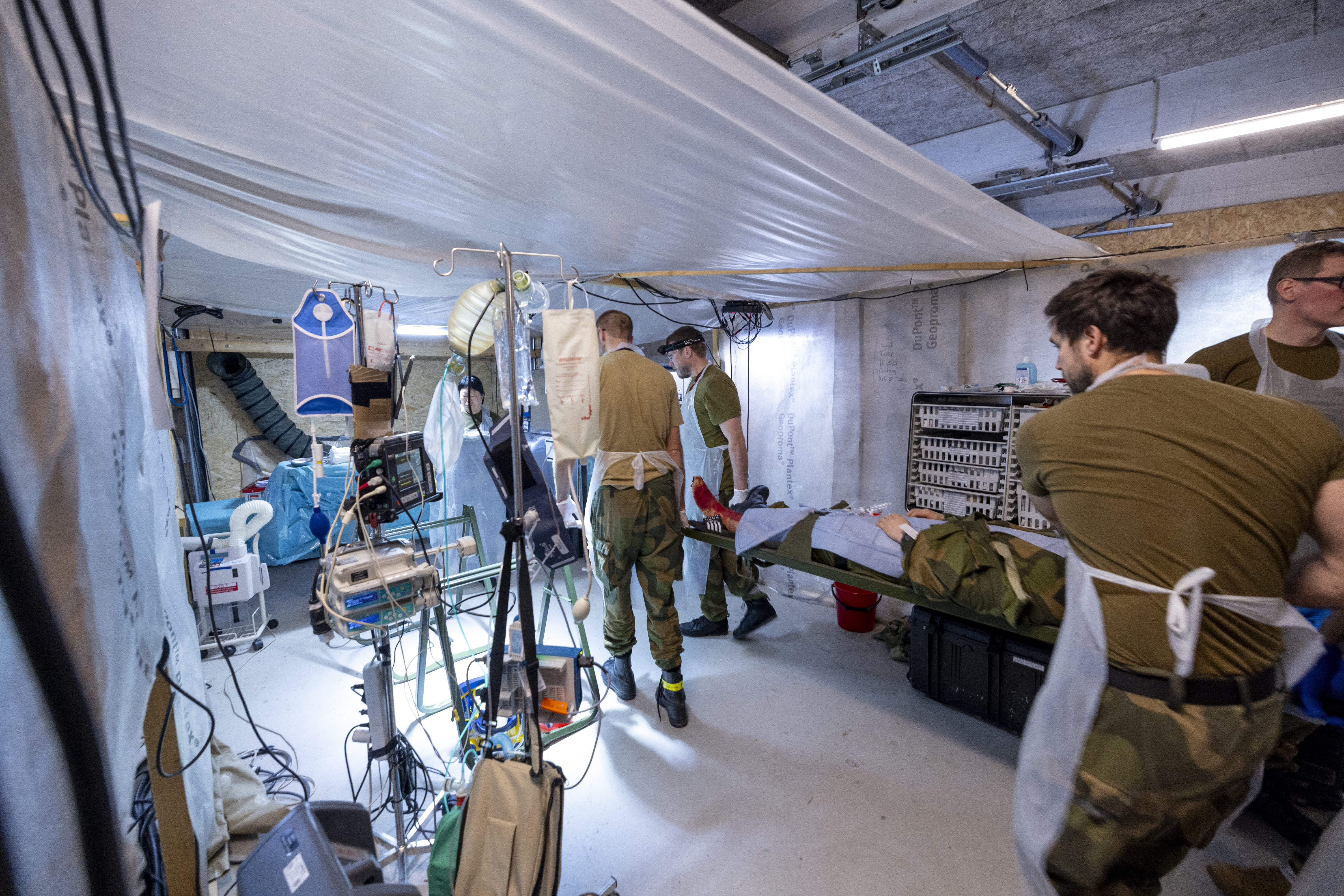 Øvelse, feltsykehus Bildet viser sanitetspersonell som bærer en pasient på båre.