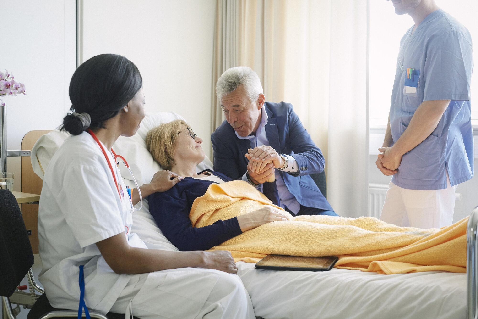 Bildet viser en pasient sammen med pårørende og helsepersonell.
