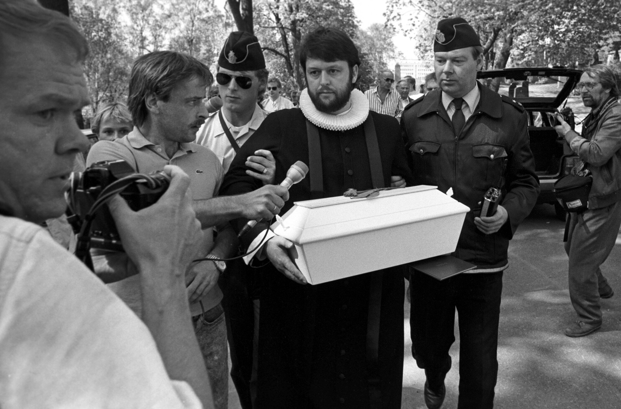 Bildet viser Ludvig Nessa med en liten kiste som blir eskortert bort av politiet Bildet viser Ludvig Nessa med en liten kiste som blir eskortert bort av politiet