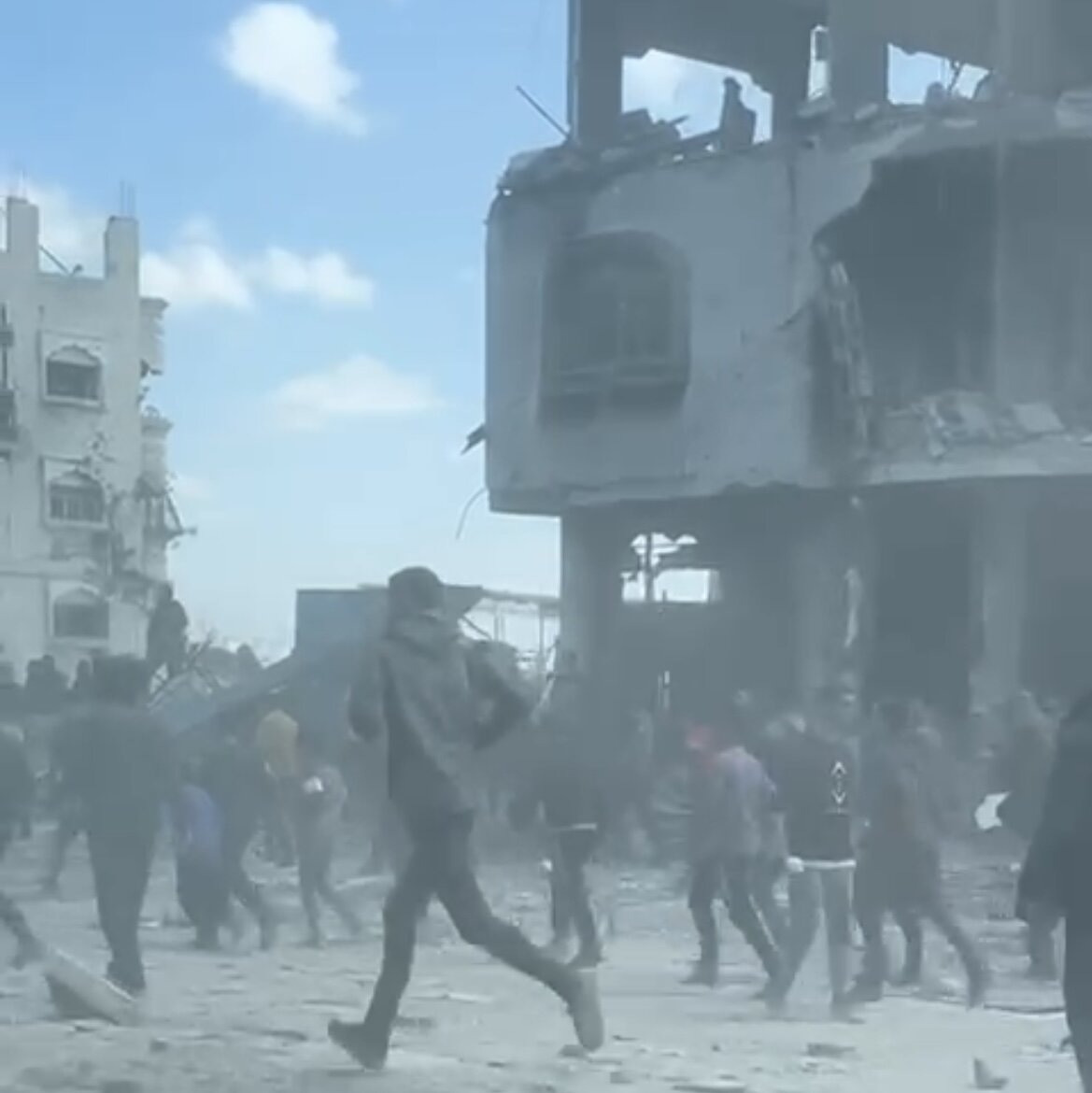 Gaza Bildet viser mennesker som løper i ruiner.