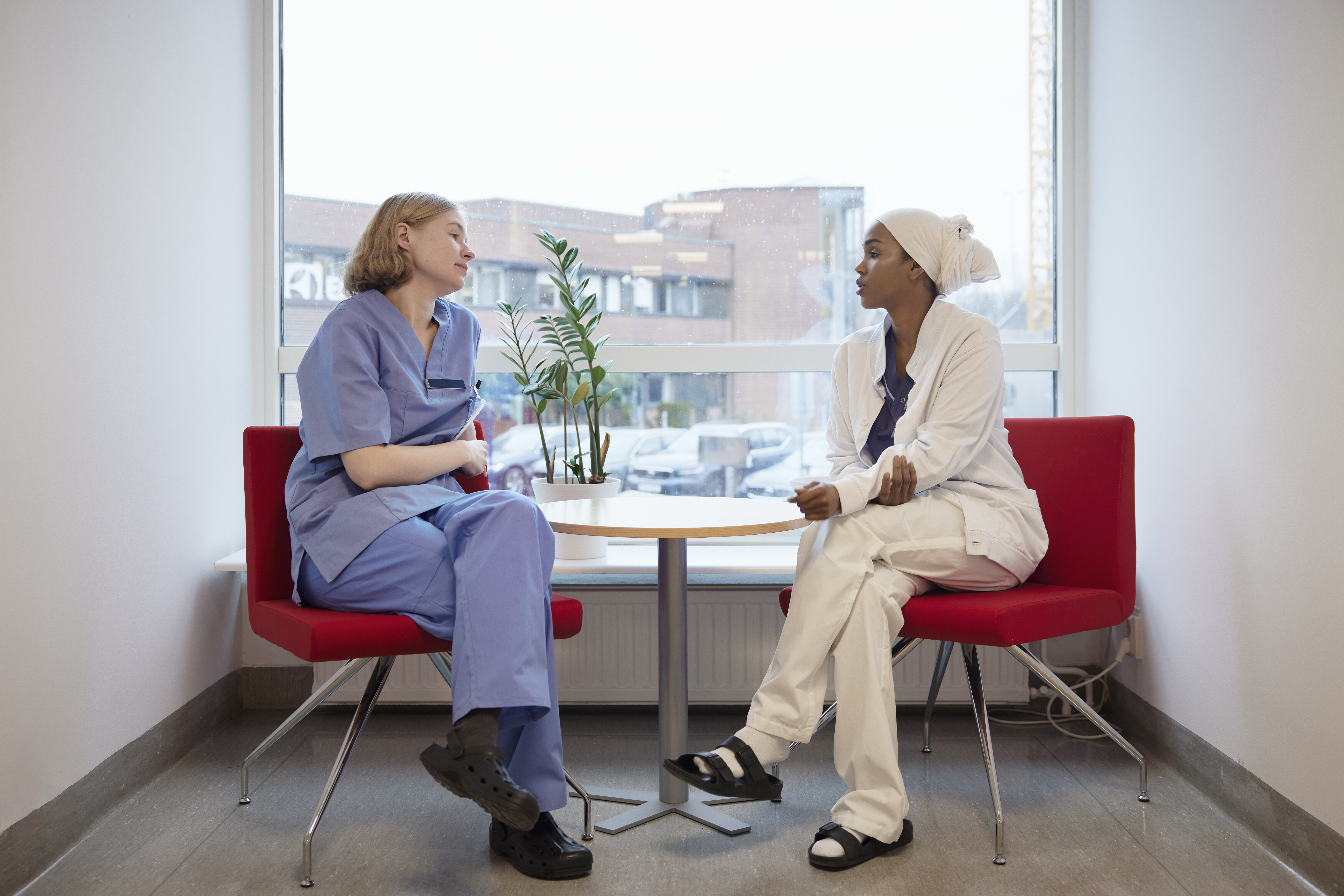 Ethical reflection The photo shows two nurses sitting and talking together in front of a window