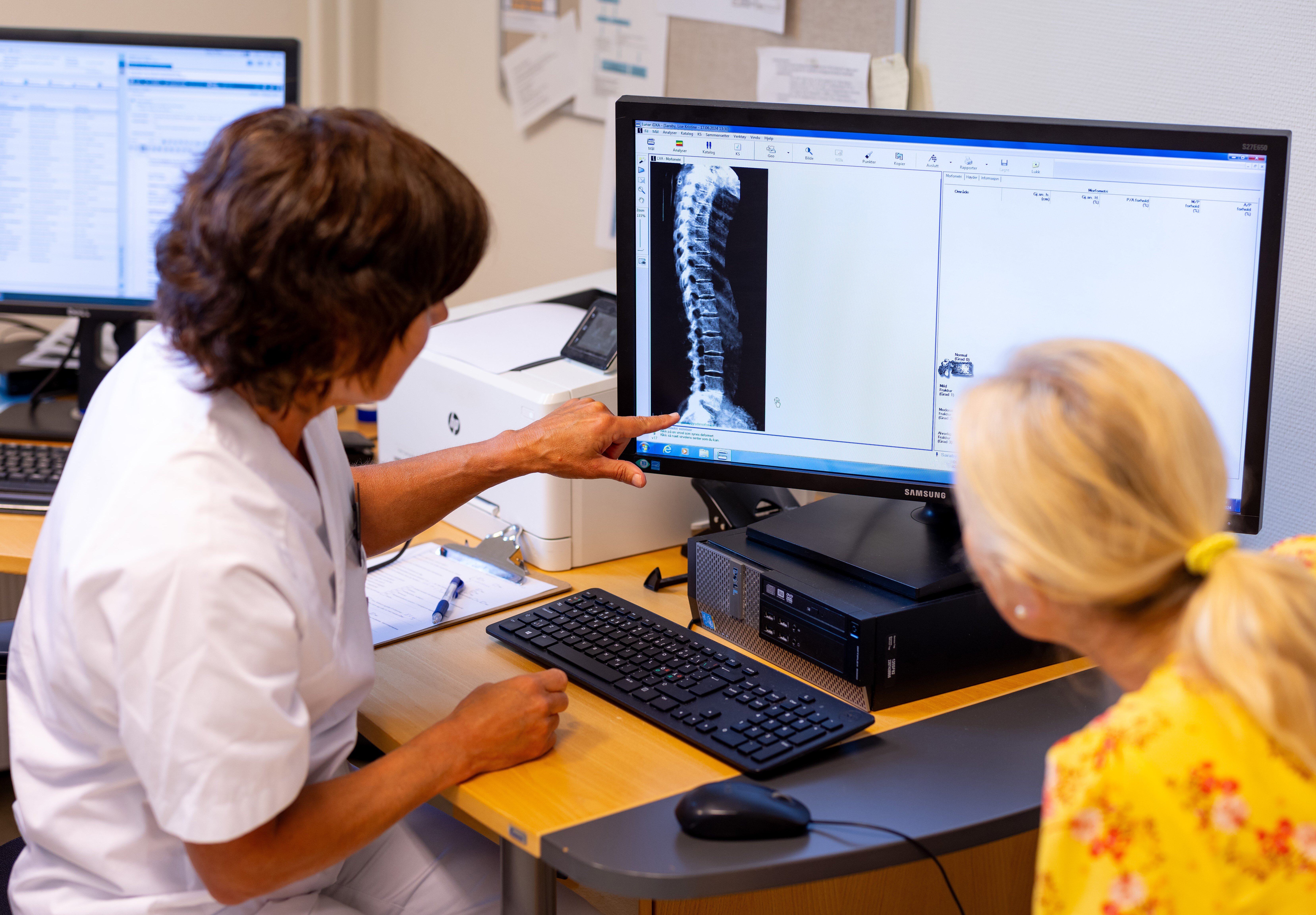 Merete Finjarn forklarer et sidebilde av ryggen til en pasient Bildet viser Merete Finjarn som forklarer et sidebilde av ryggen til en pasient