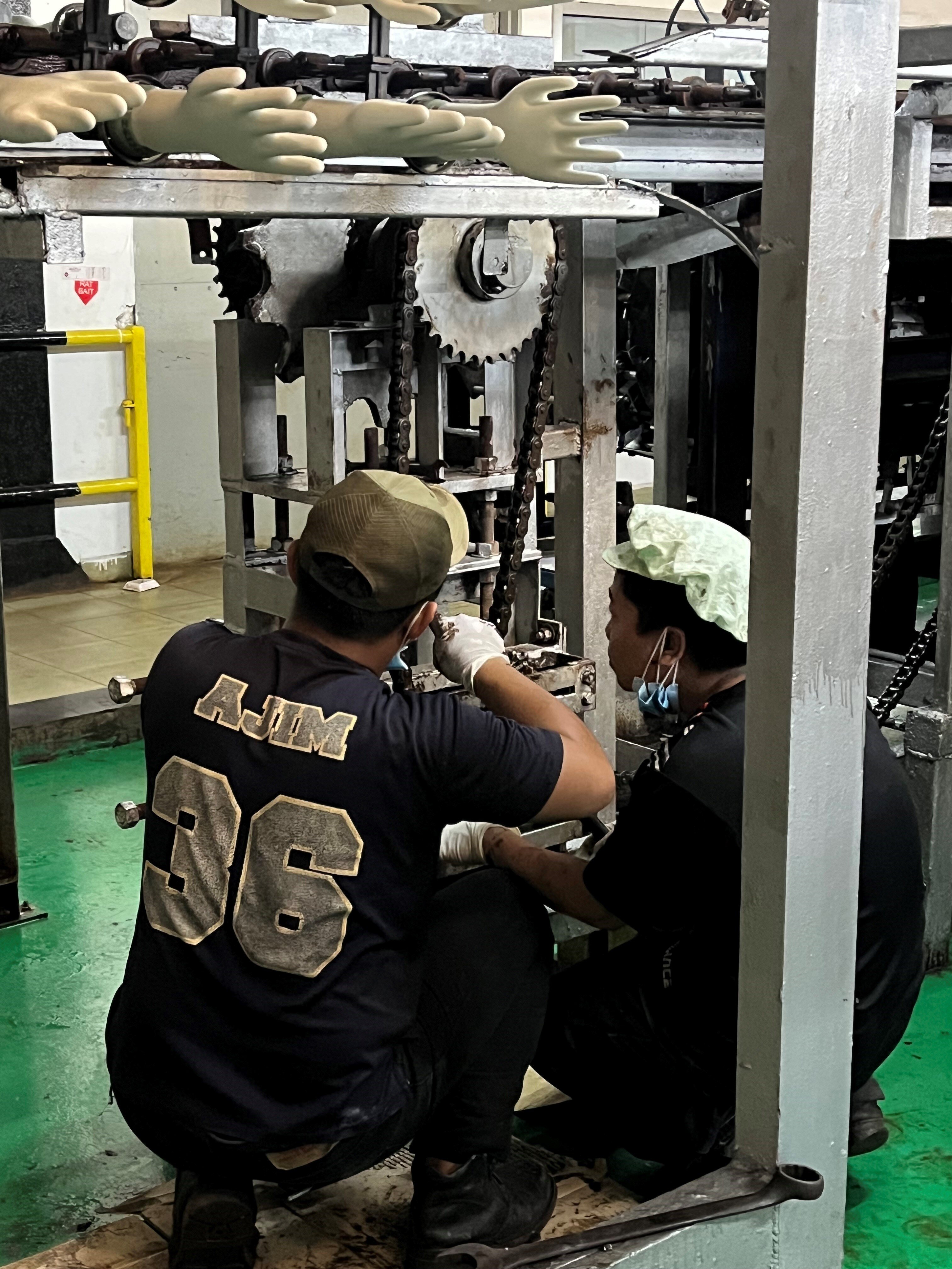 Bildet viser Vedlikeholdsarbeid på en hanskeproduksjonslinje i Malaysia 2023.