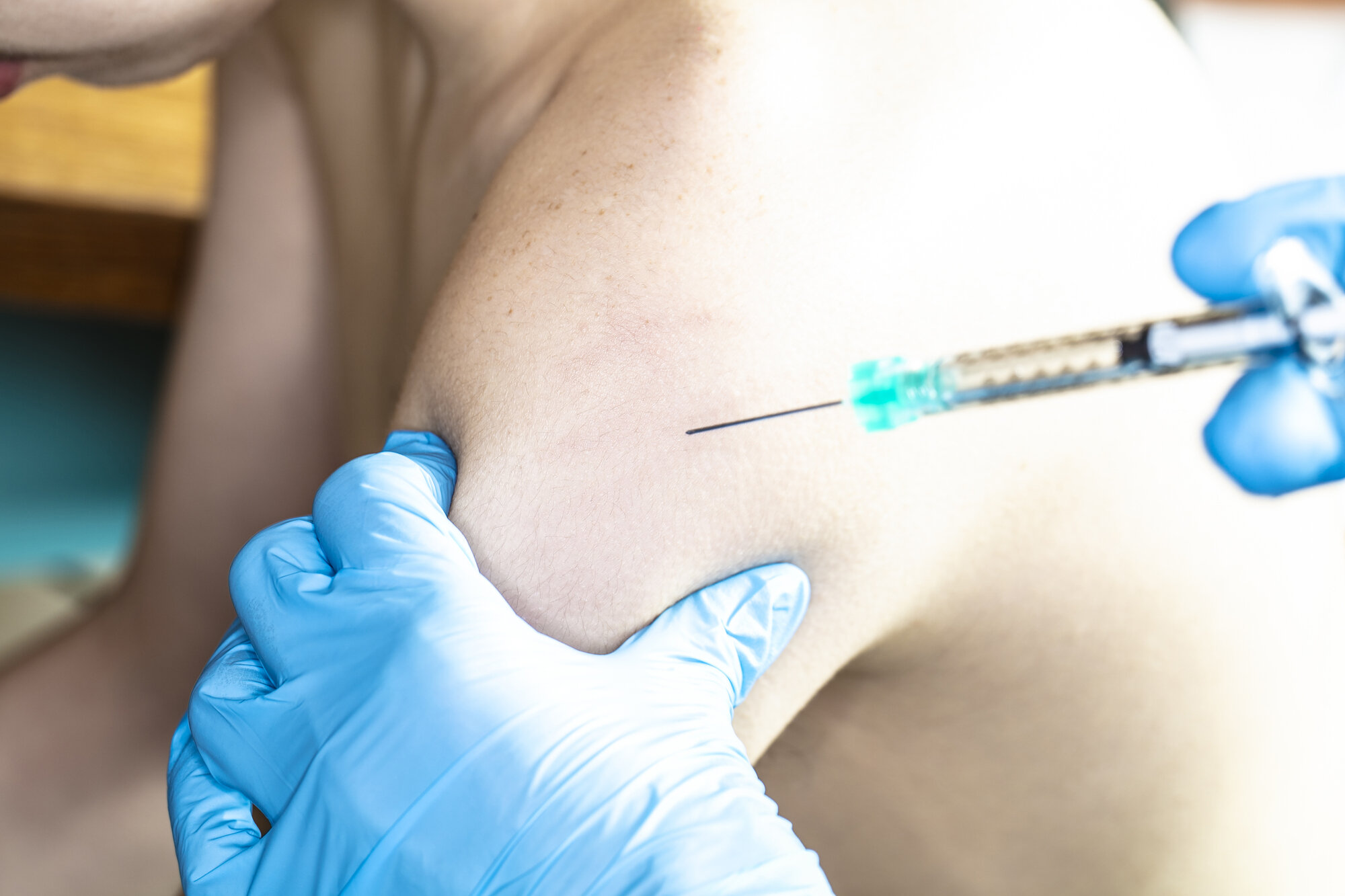 Bildet viser en person som får en sprøyte i skulderen
