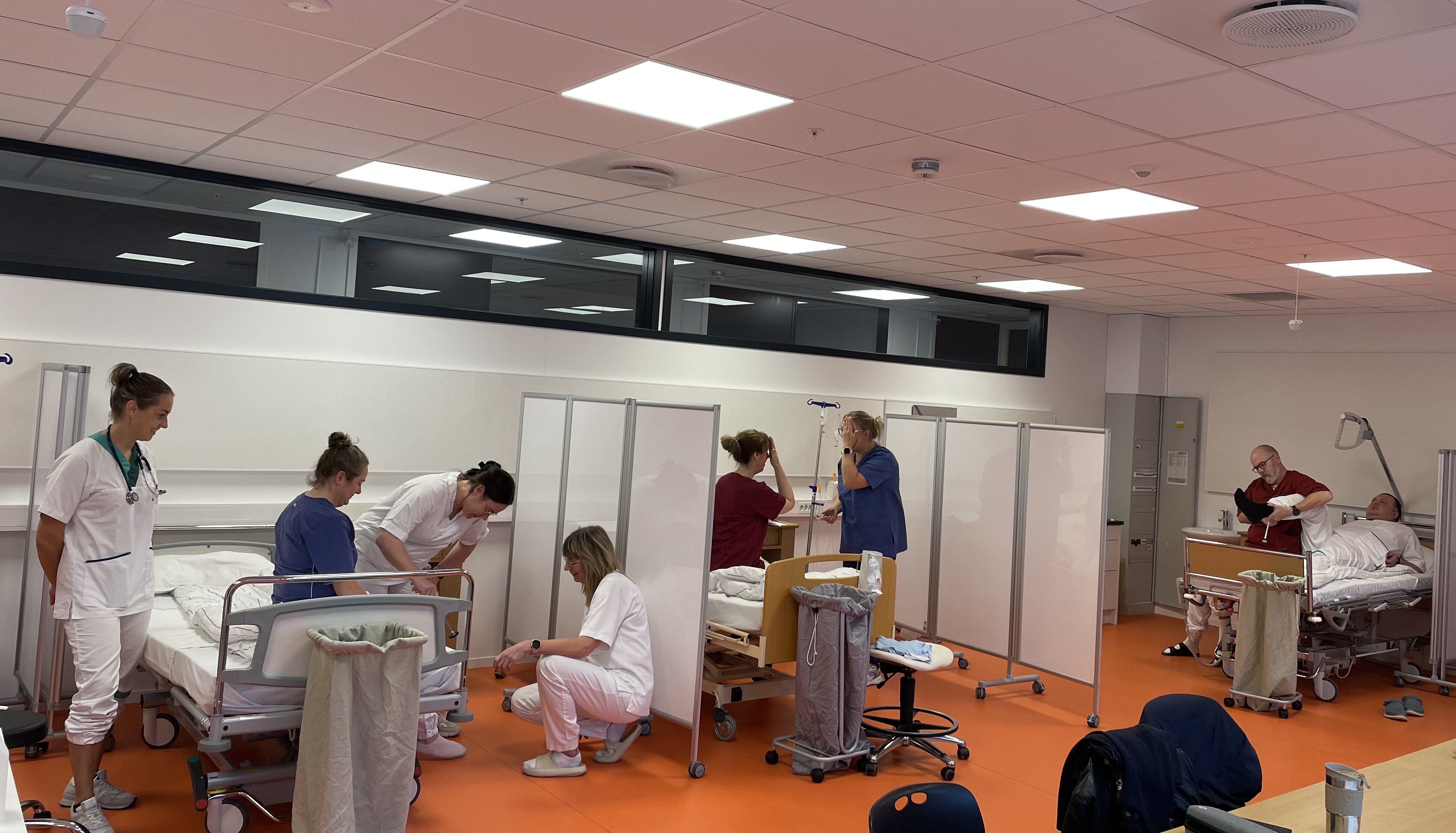 Bildet viser AKS-studenter som øver ved seng. Bildet viser AKS-studenter som øver ved seng.