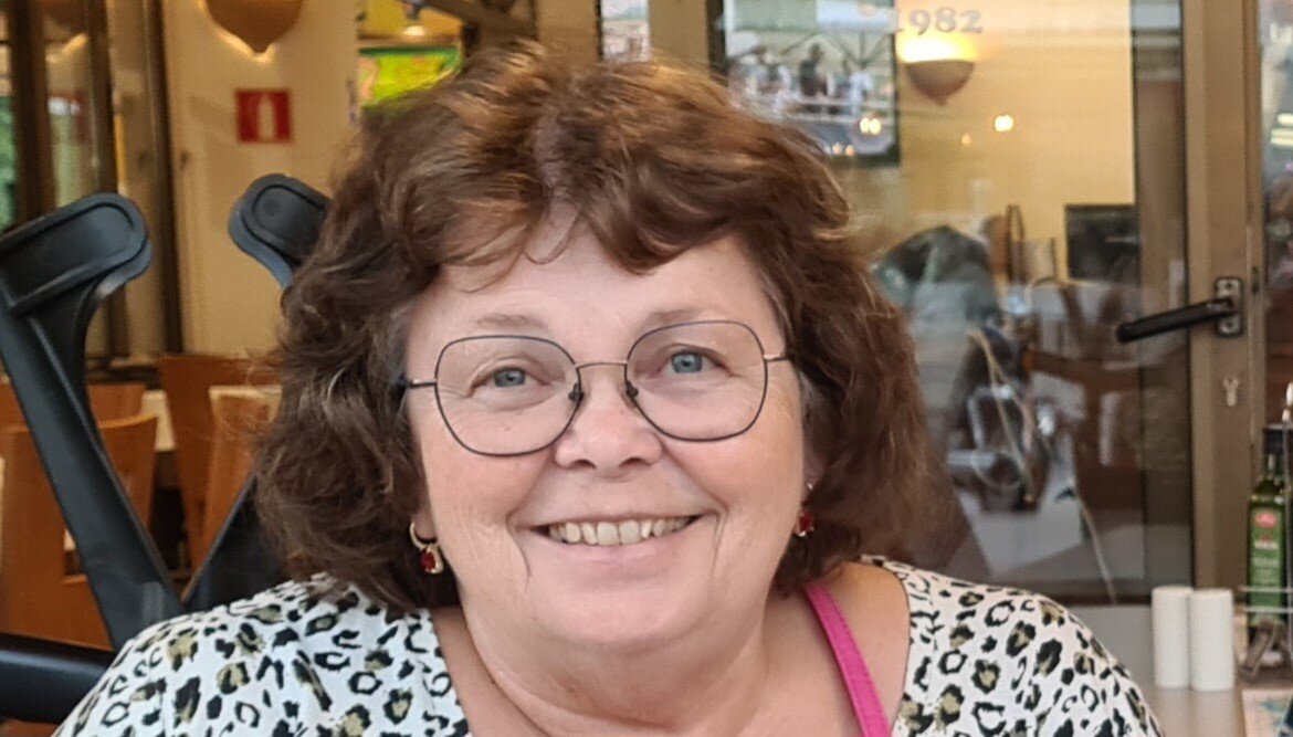 Portrett av en dame som smiler til kameraet.