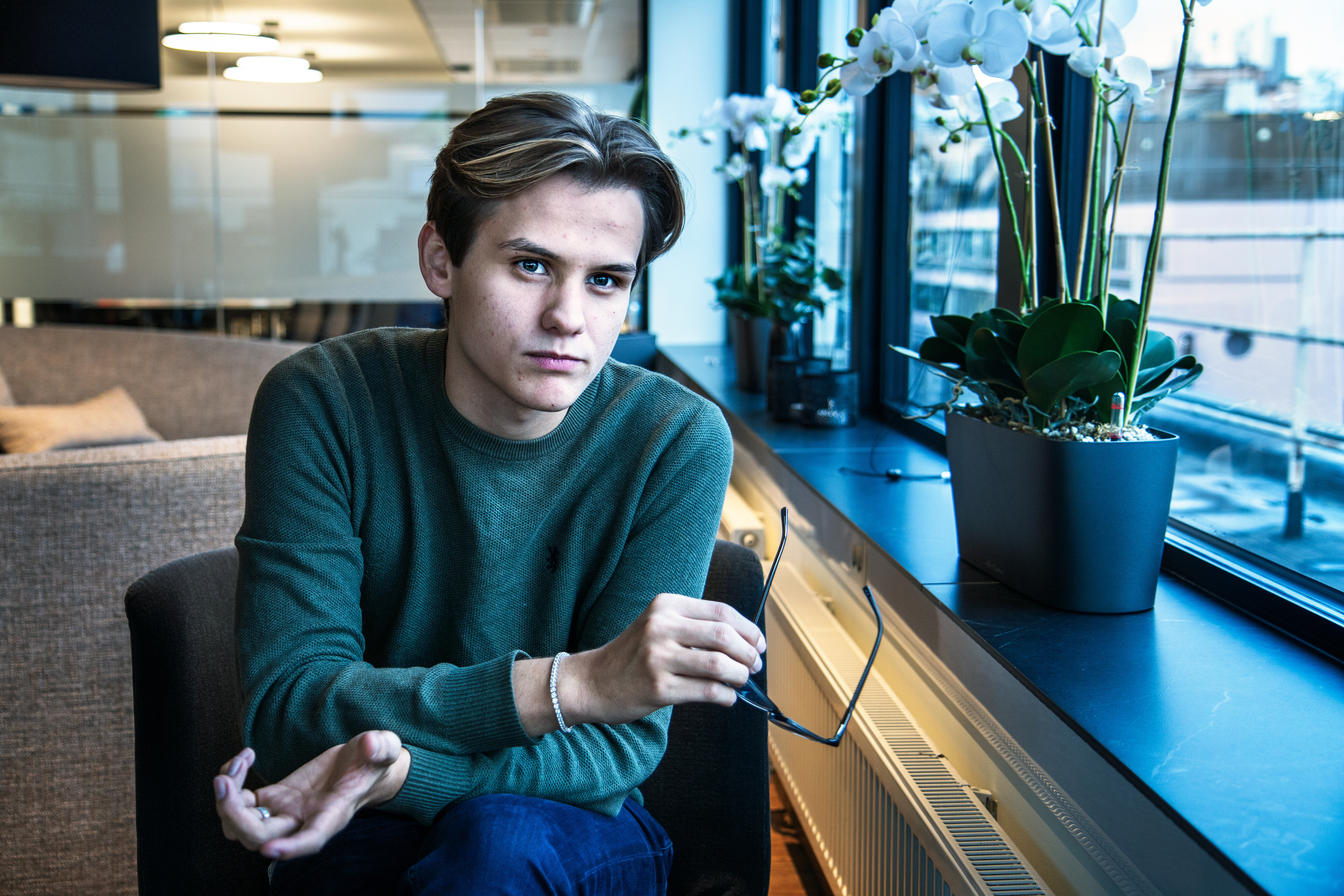 Bilde av Kristoffer Haugen, studentleder, som ser inn i kamera. Han holder briller i hånden.