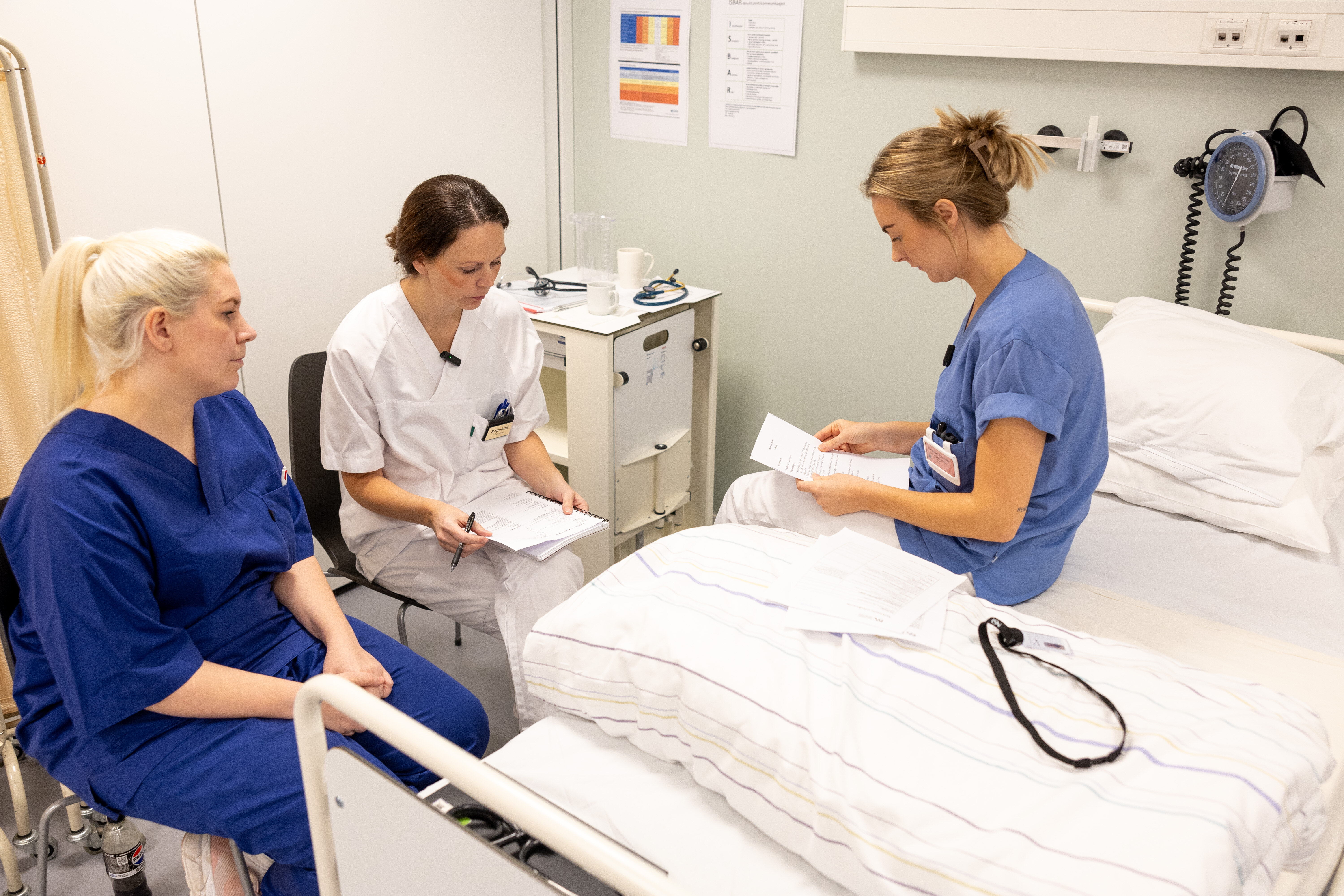 Førsteårsstudentene øver på å få pasienter til å fortelle om symptomer: Charlotte Tovesen spiller "kvinne 39 år", og Ragnhild Bjåsteed Berget tar anamnese. Andreårsstudent Kristina Aunet observerer og veileder.