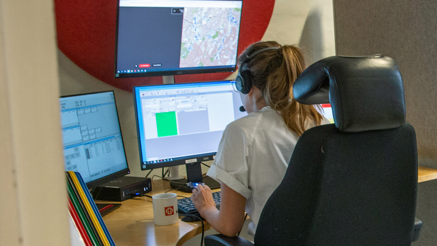Telefonoperatør ved det medisinske nødsentralen. Bildet viser en telefonoperatør som sitter ved det medisinske nødsentralen foran mange dataskjermer.