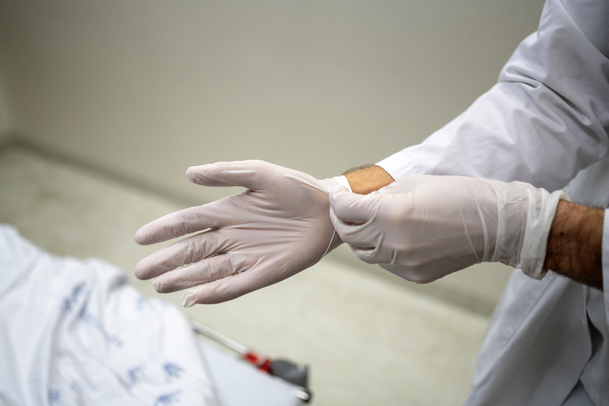 Bilde av helsepersonell som tar på seg hansker