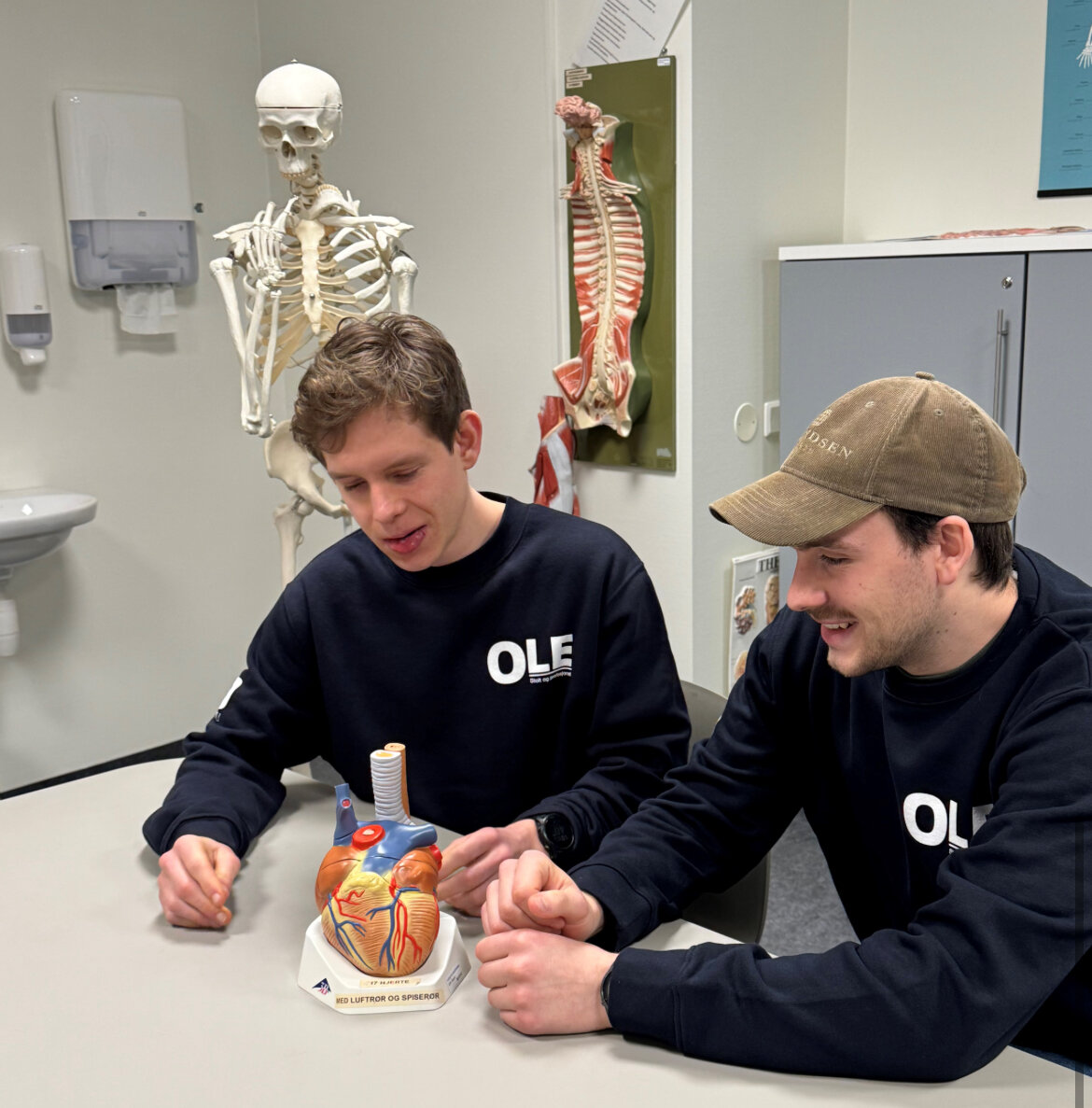 Gutter, sykepleierstudenter Bildet viser to gutter med en modell av er hjerte.