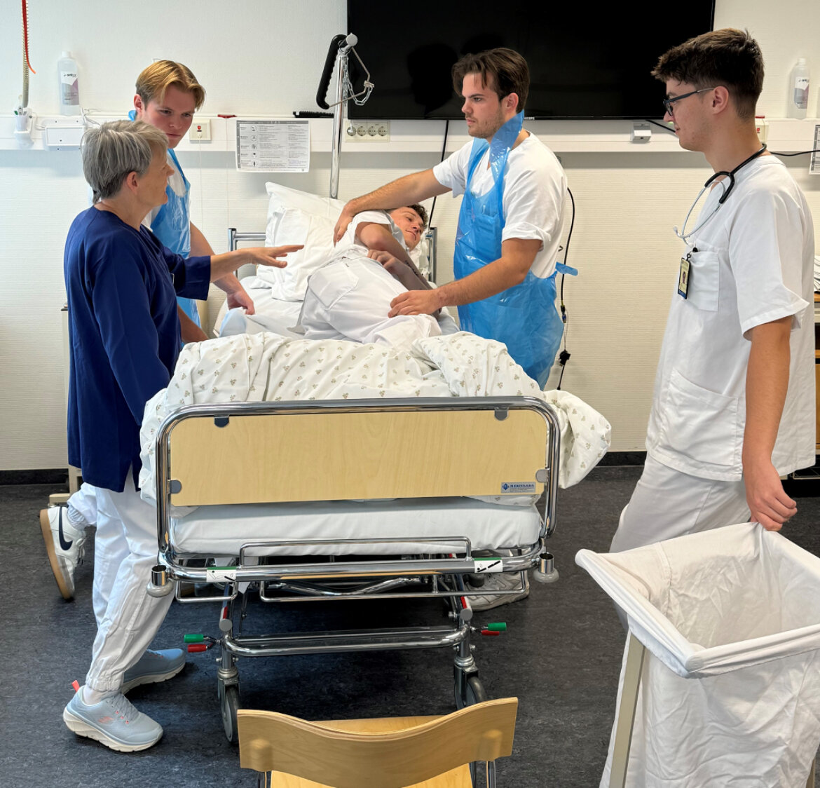 Mannlige sykepleierstudenter Bildet viser mannlige sykepleierstudenter som steller medstudent.