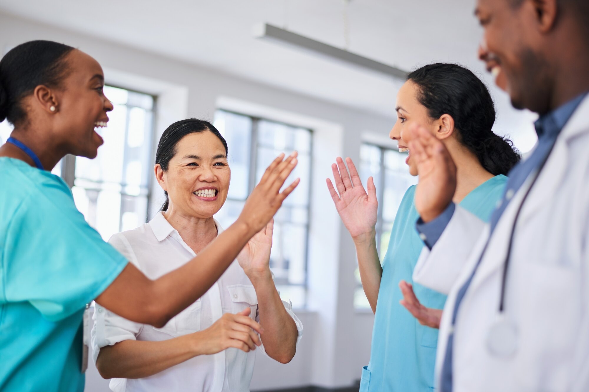 Bildet viser fire sykepleiere av ulik etnisitet