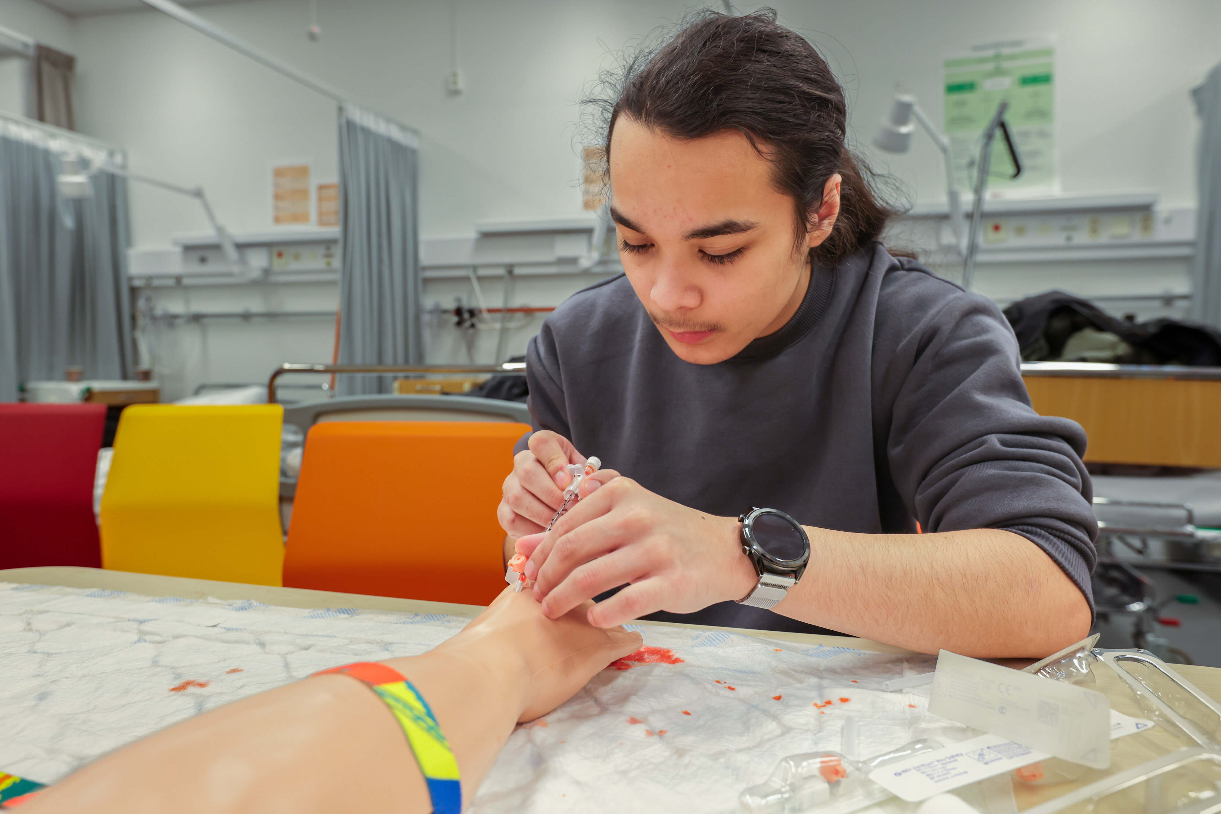 Skoleelev prøver seg på innsetting av PVK i Tromsø