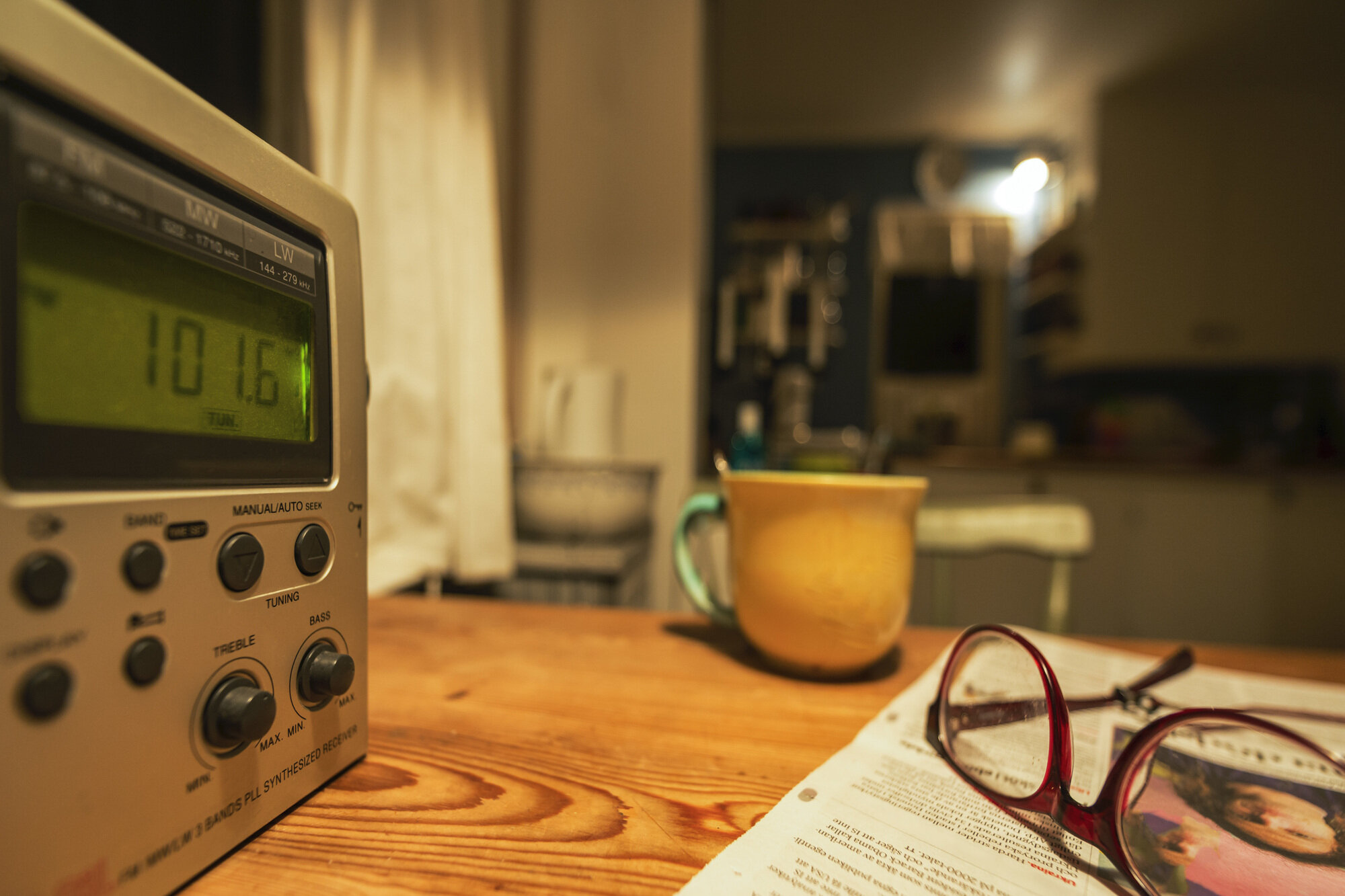 Bildet viser radio, kopp og briller på bord. Illustrasjonsfoto. Bildet viser radio, kopp og briller på bord. Illustrasjonsfoto.