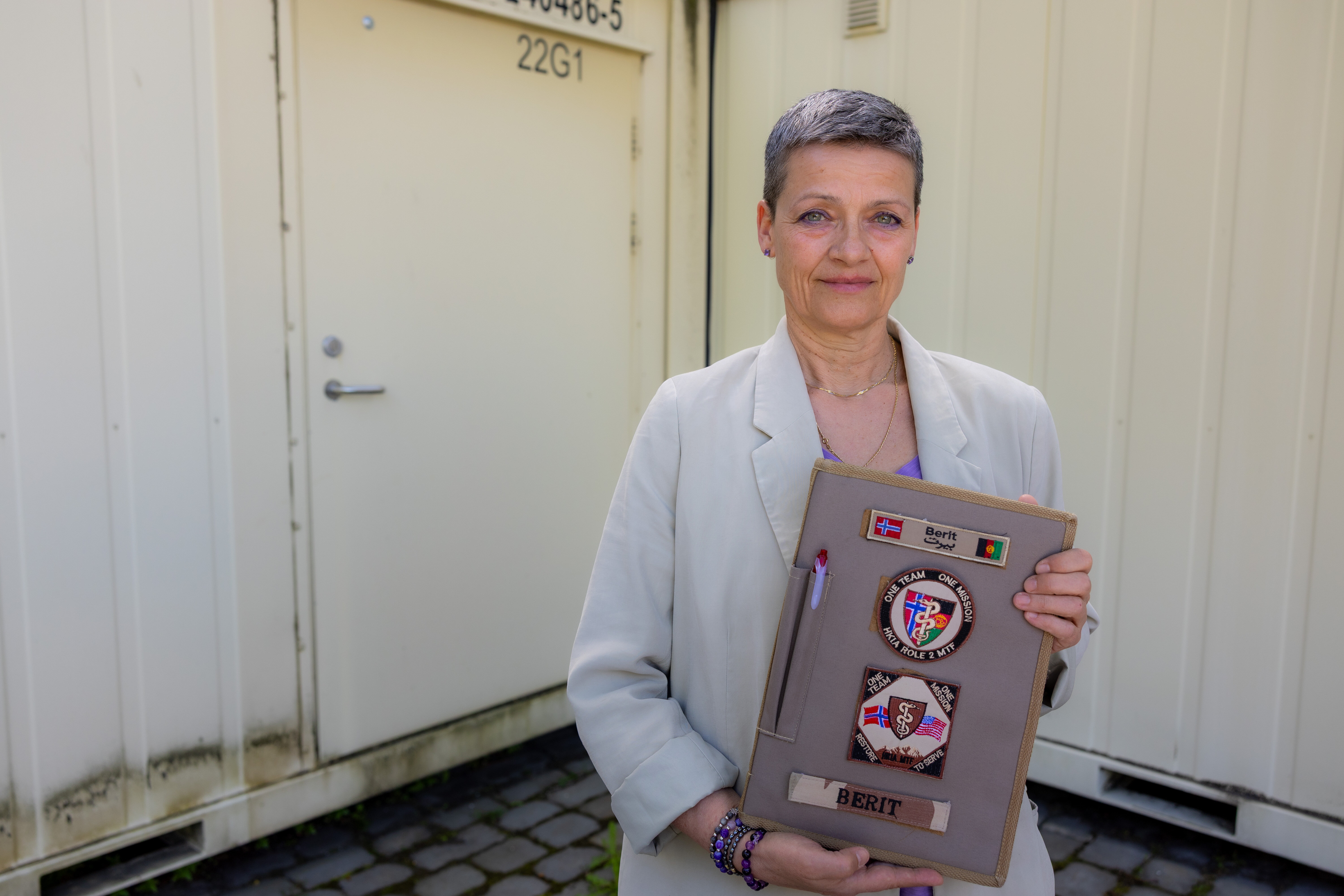 Bildet viser Berit Karita Mørseth med en bok som har patchen på forsiden.