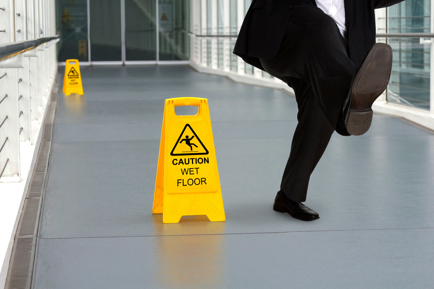 Bildet viser mann som faller på vått gulv