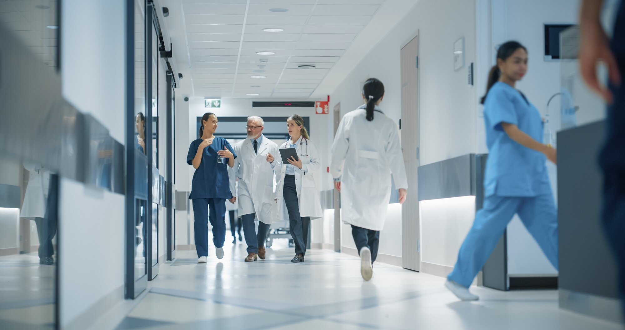 Bildet viser et tverrprofesjonelt team som går i gangen på et sykehus