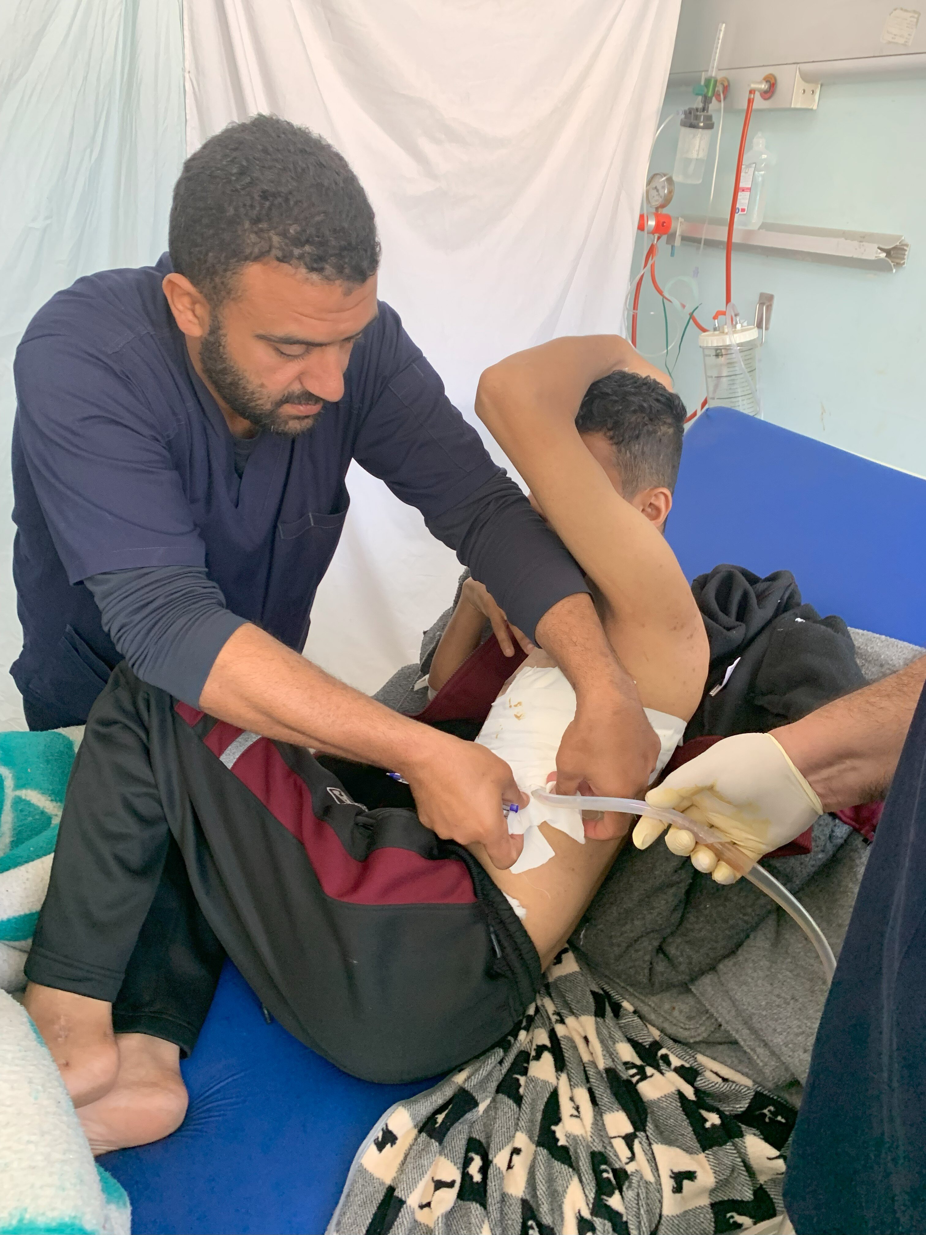 Bildet viser en sykepleier i Gaza som steller en pasient