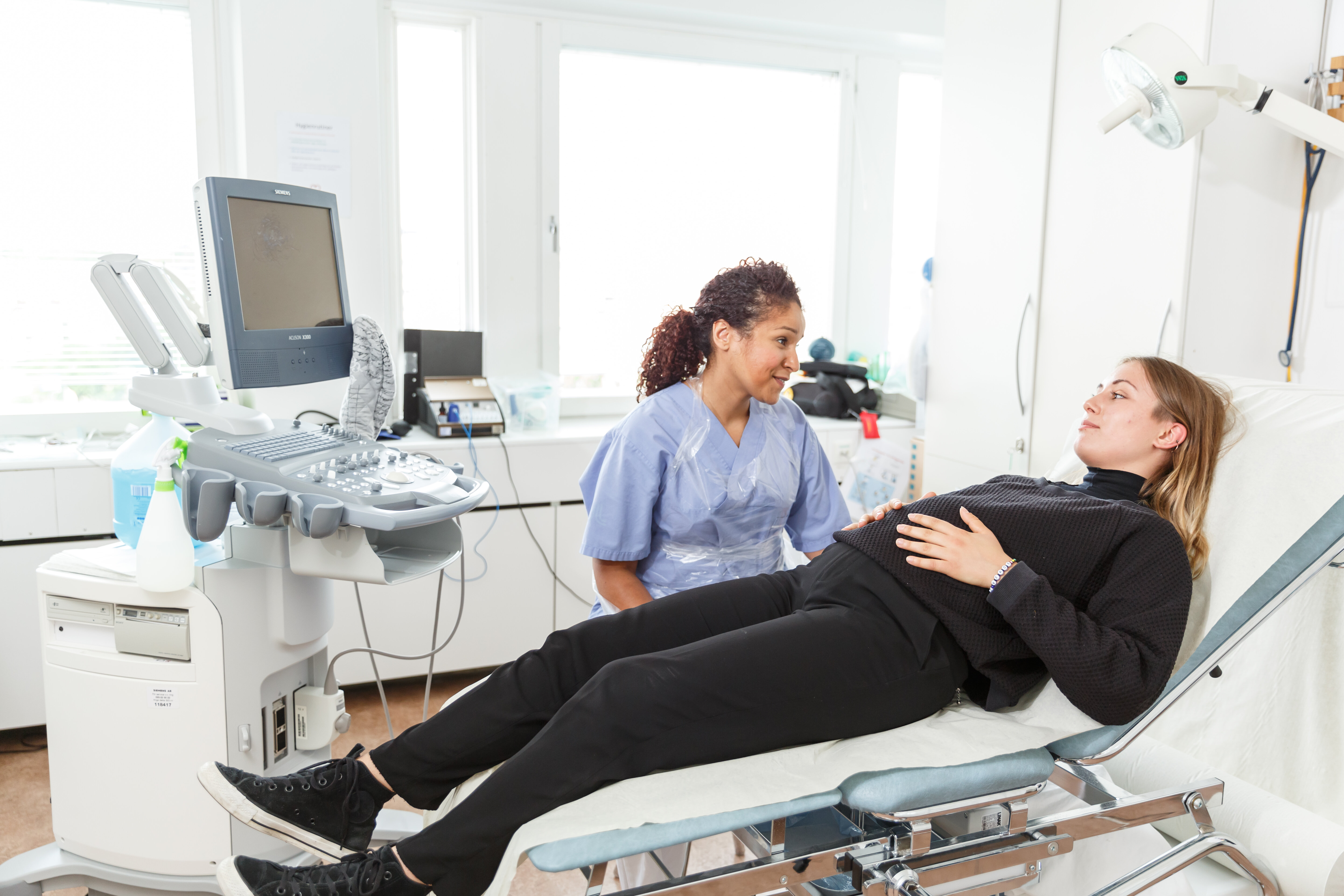 en jordmor på jobb med gravid kvinne bildet viser en jordmor på jobb med gravid kvinne