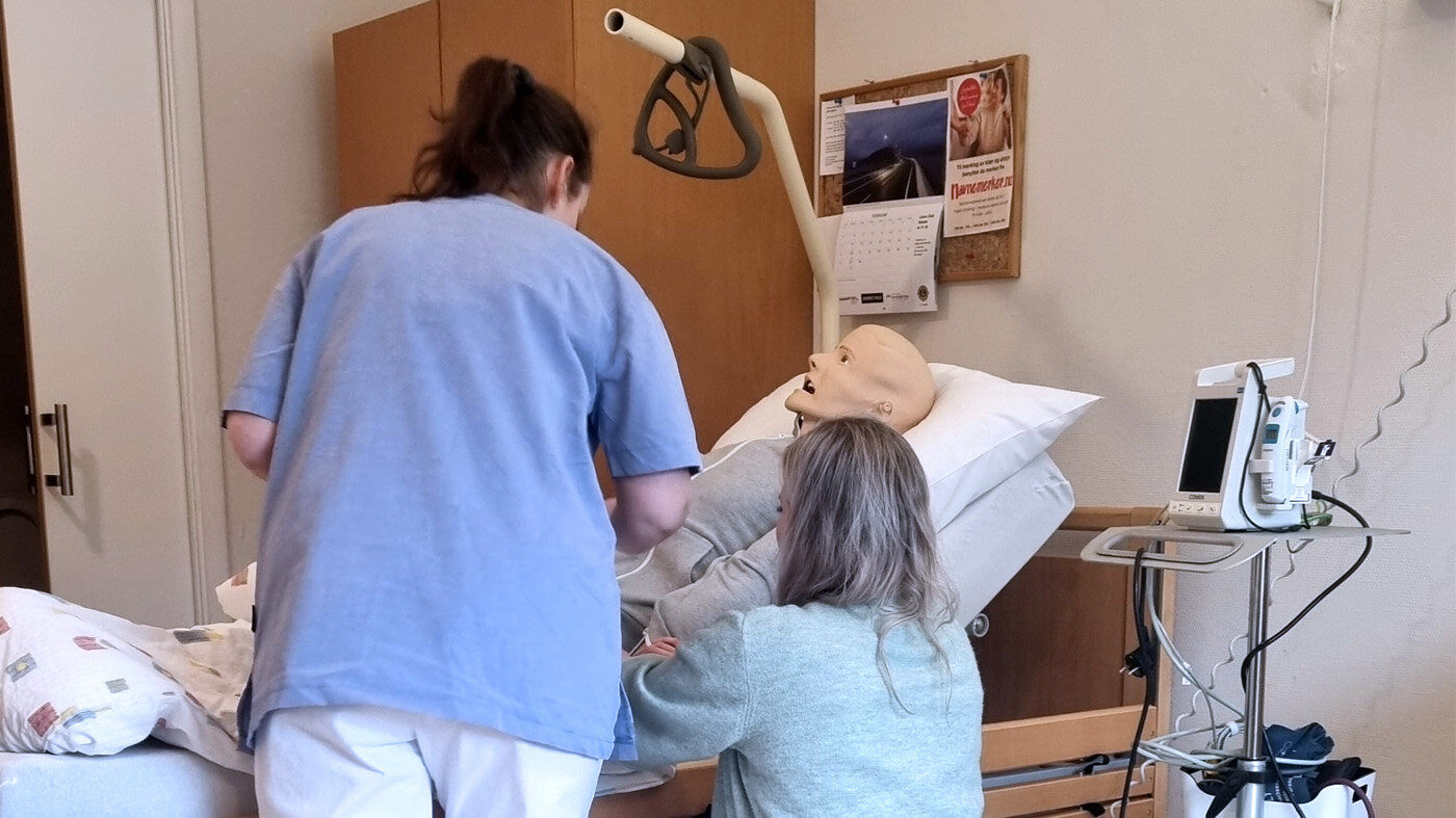 Bildet viser to sykepleiere i gang med å utføre målinger, som er del tre i TVS-modellen