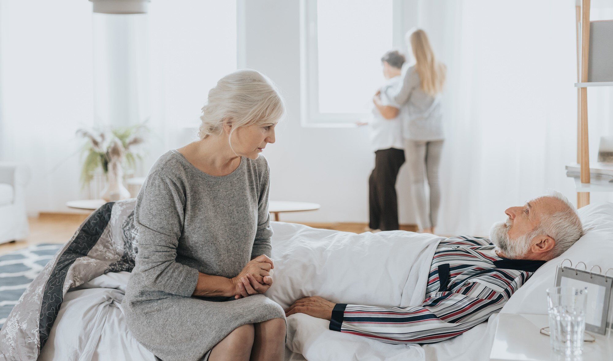 Bildet viser en mann som dør hjemme med familien rundt seg