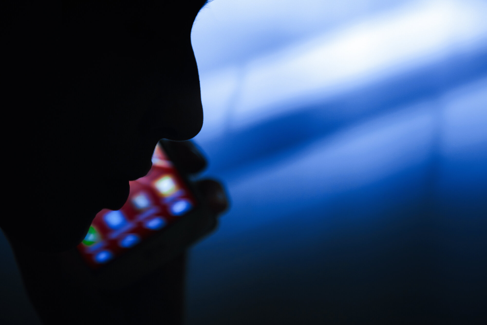 Bildet viser siluett av en dame som snakker i telefonen Bildet viser siluett av en dame som snakker i telefonen