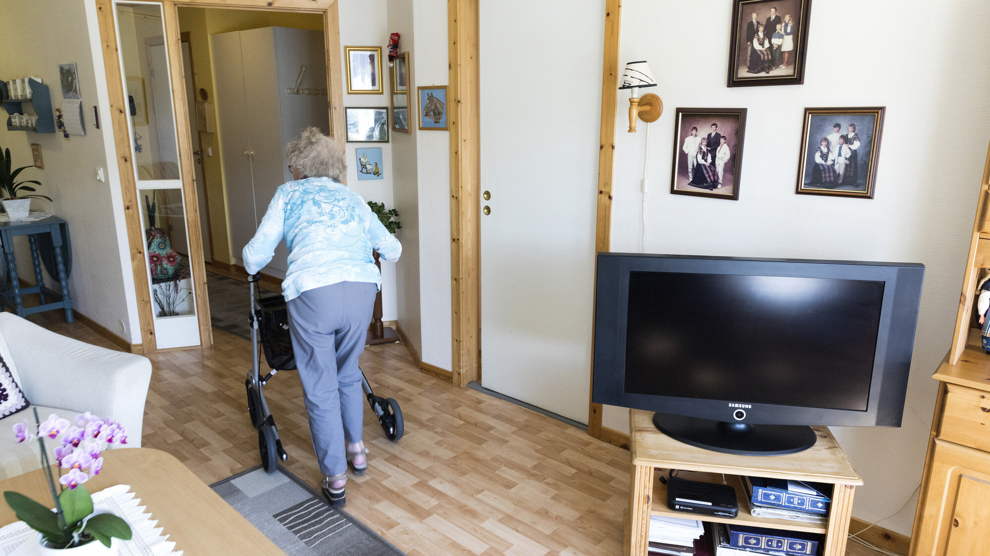 Bildet viser en eldre kvinne med rullator i sitt hjem