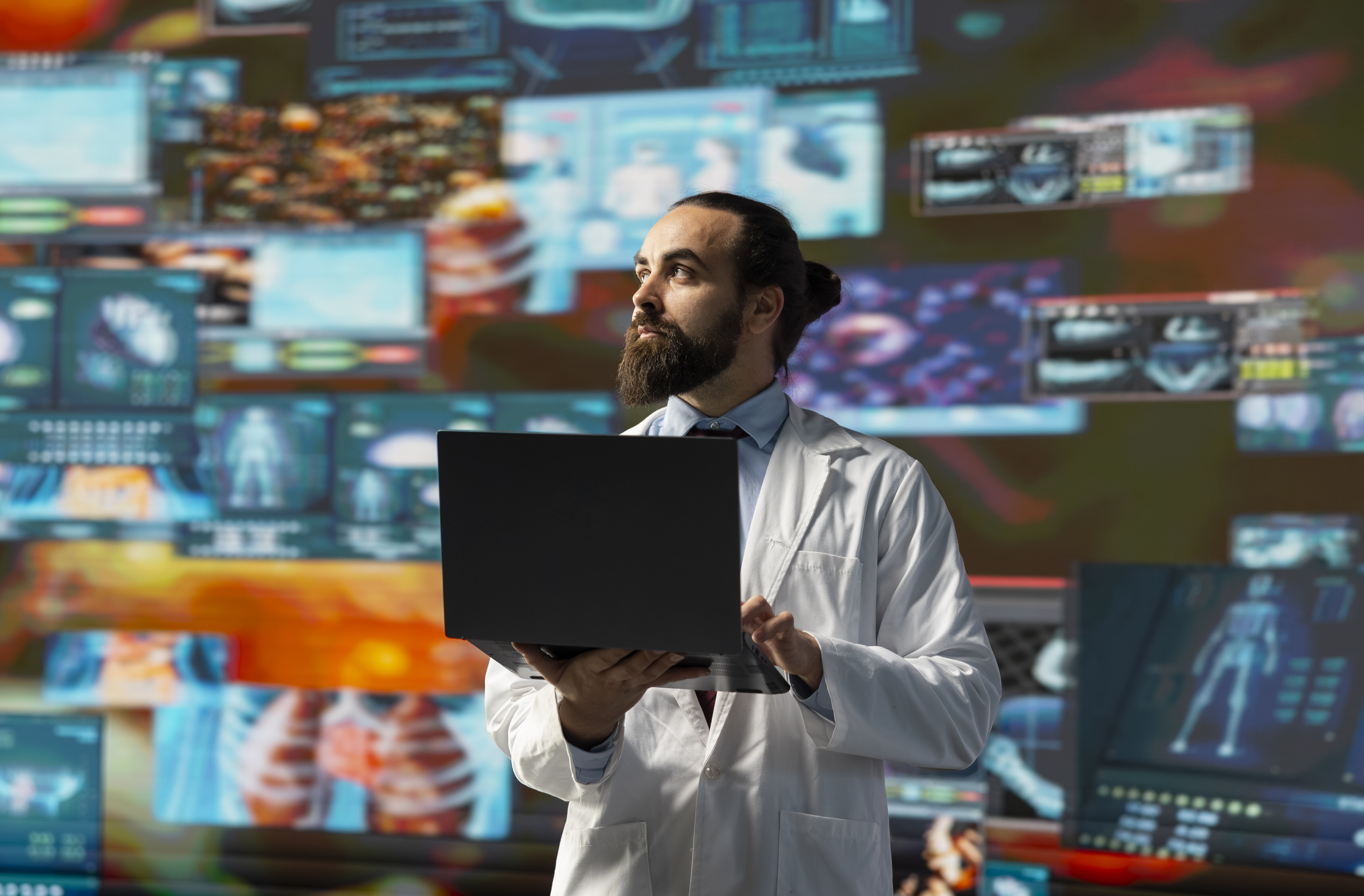 bildet viser sykepleier med pc mot fargerike skjermer