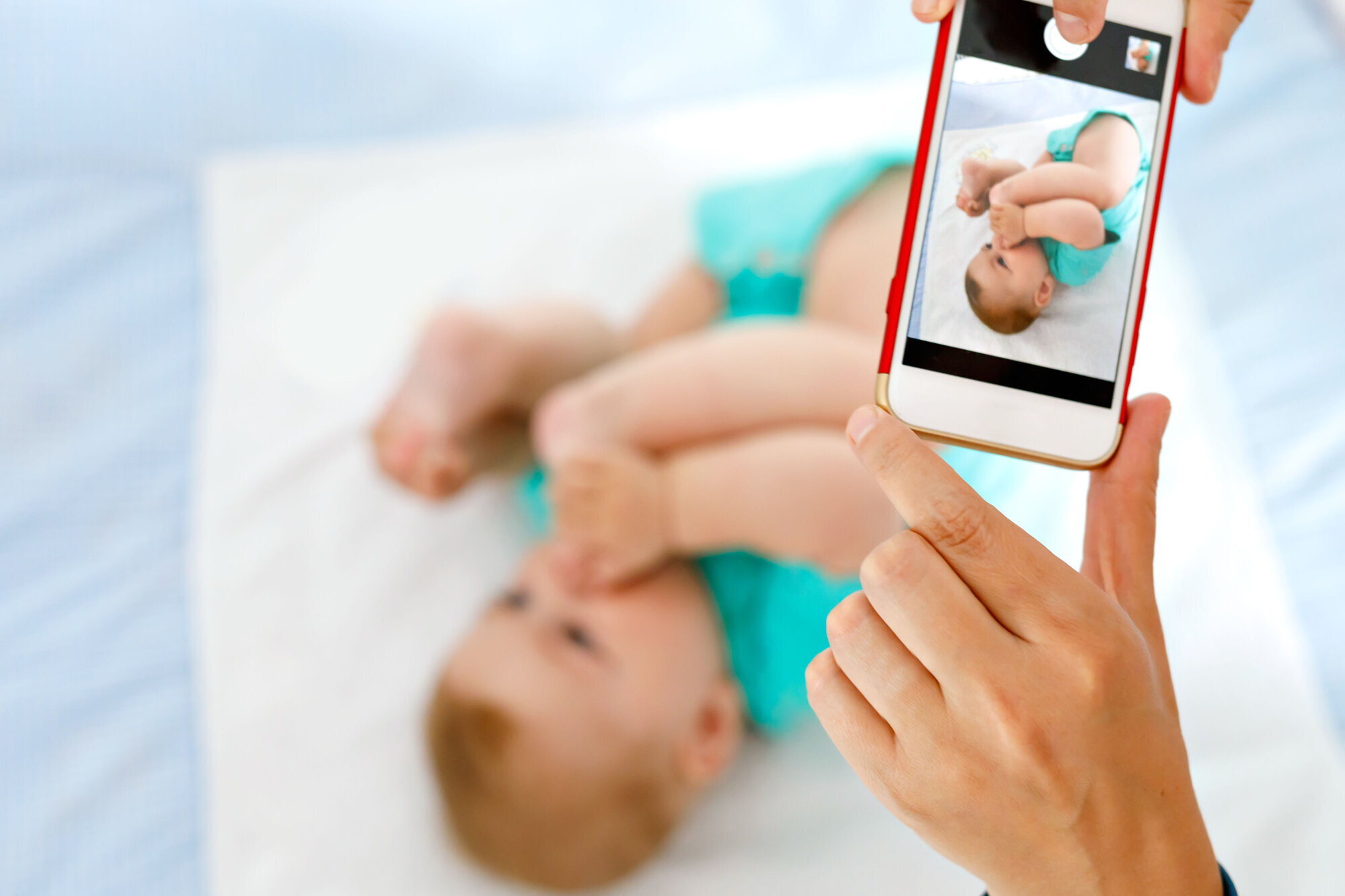 Noen tar bilde av en baby med mobiltelefonen. Noen tar bilde av en baby med mobiltelefonen.