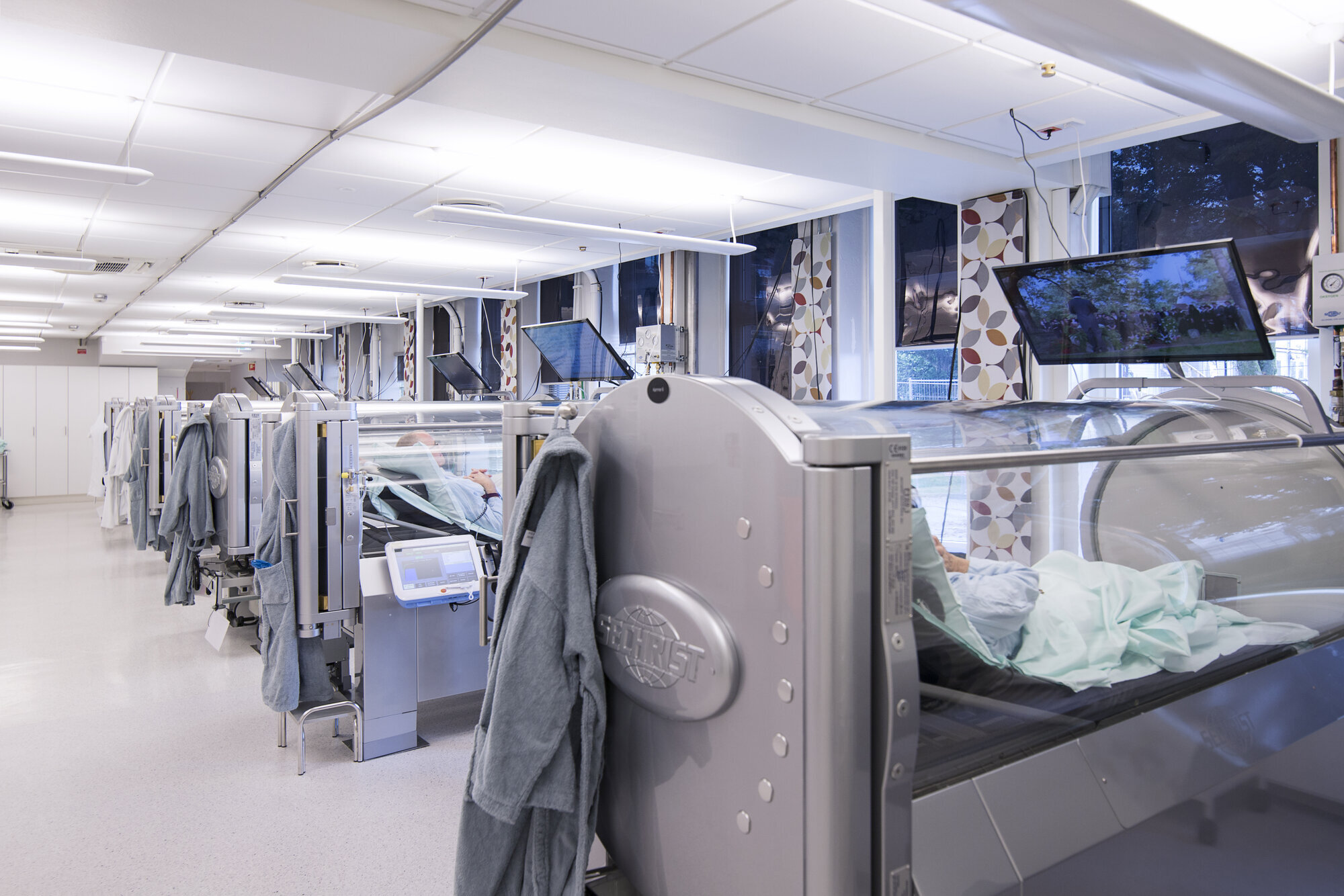 Trykkkamre Bildet viser flere trykkamre på rekke og rad, der folk behandles for blant annet stråleskader