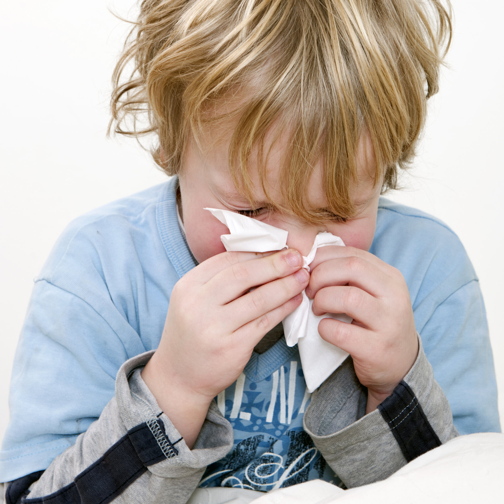 Barn snyter seg i et lommetørkle. Barn snyter seg i et lommetørkle.