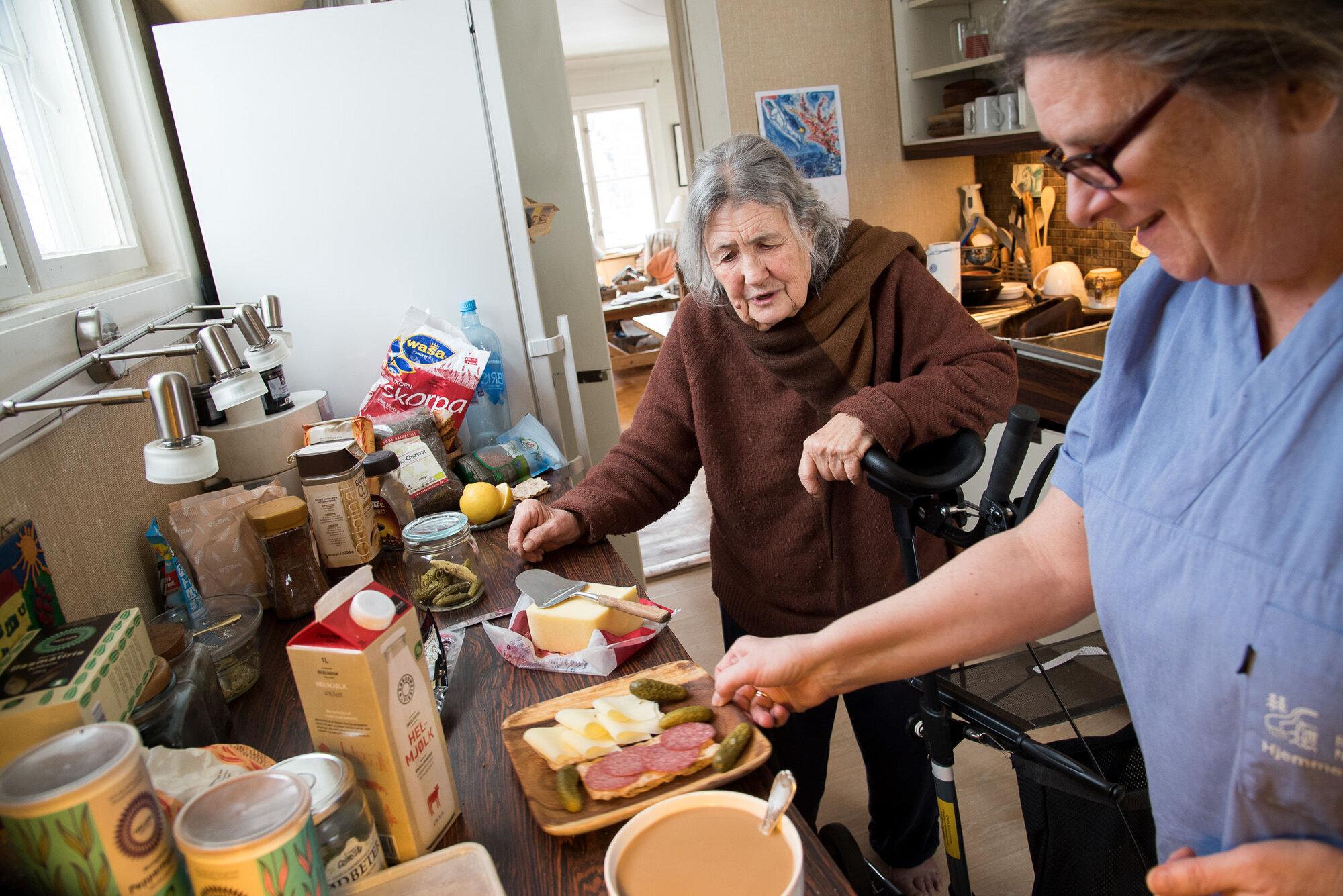 Hjemmesykepleier tilbereder måltid. Bildet viser en hjemmesykepleier som tilbereder et måltid til brukeren.