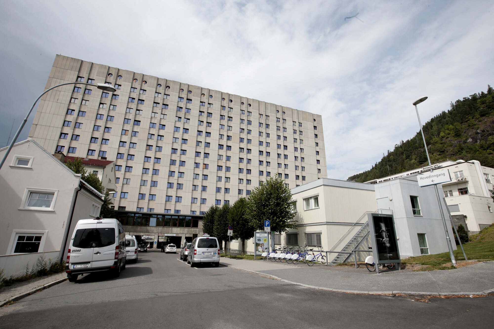  Sykehus med hvite biler utenfor. Høy hvit bygning, flere sidebygninger. 