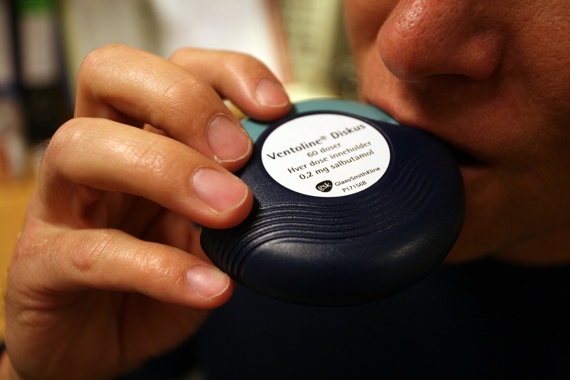 Viser en mann som inhalerer astmamedisin Viser en mann som inhalerer astmamedisin