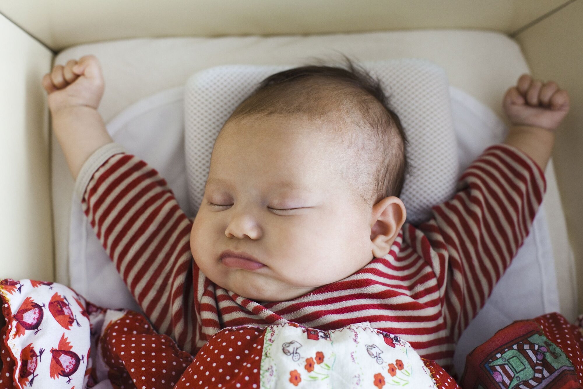 Søt baby Baby som ligger i seng og strekker seg.