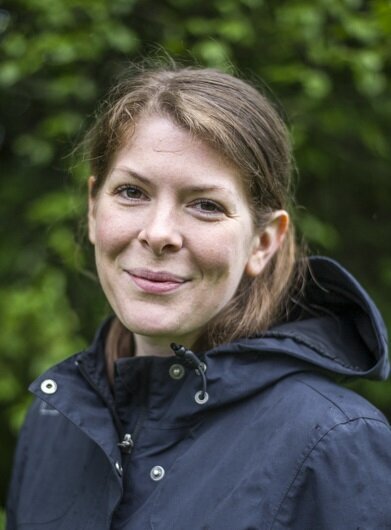 Portrett norsk ung kvinne med mørkt hår, smiler 