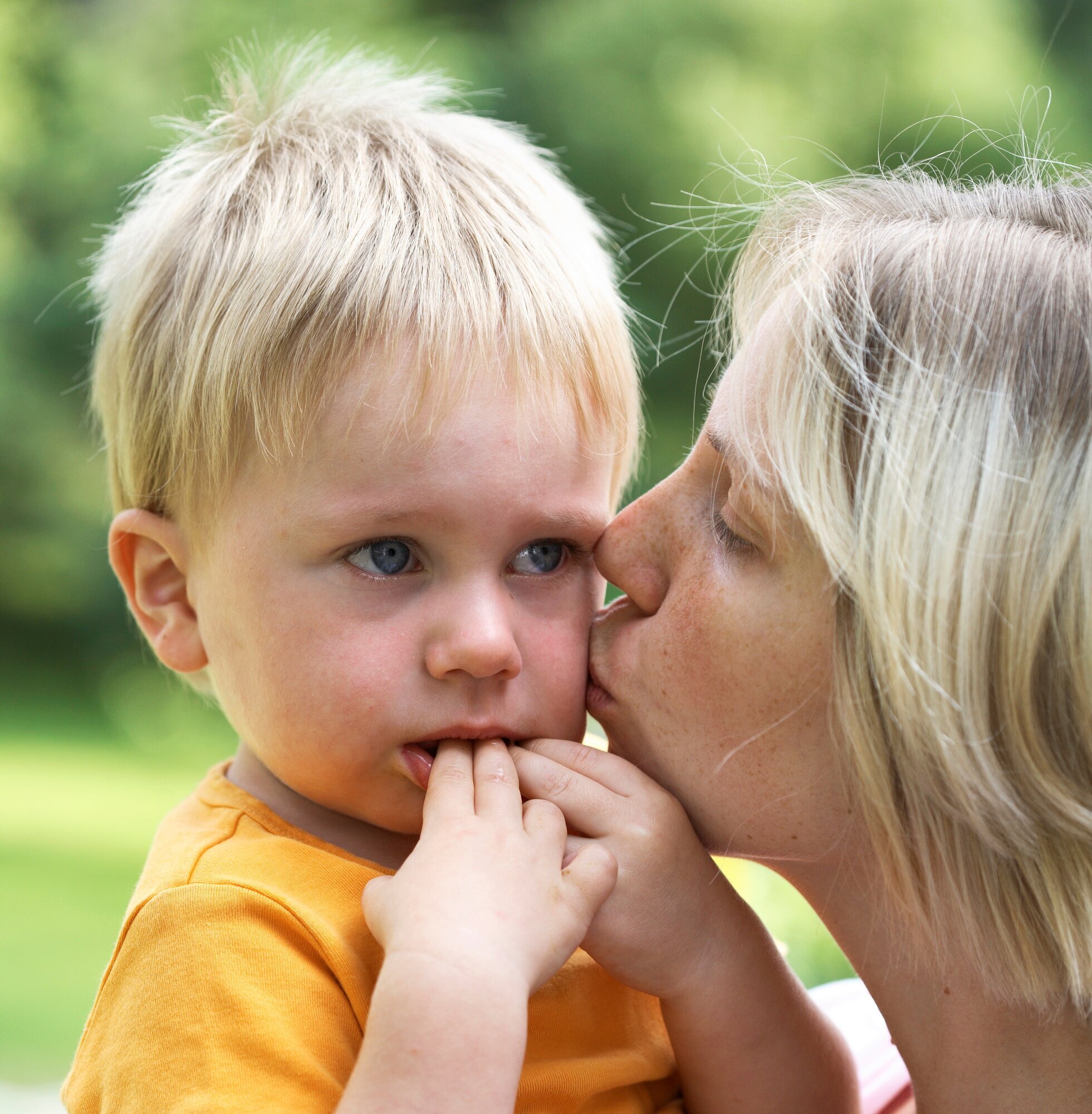 Mor, barn, trøst Bildet viser en liten gutt som gråter og som får kyss på kinnet av en kvinne til trøst.
