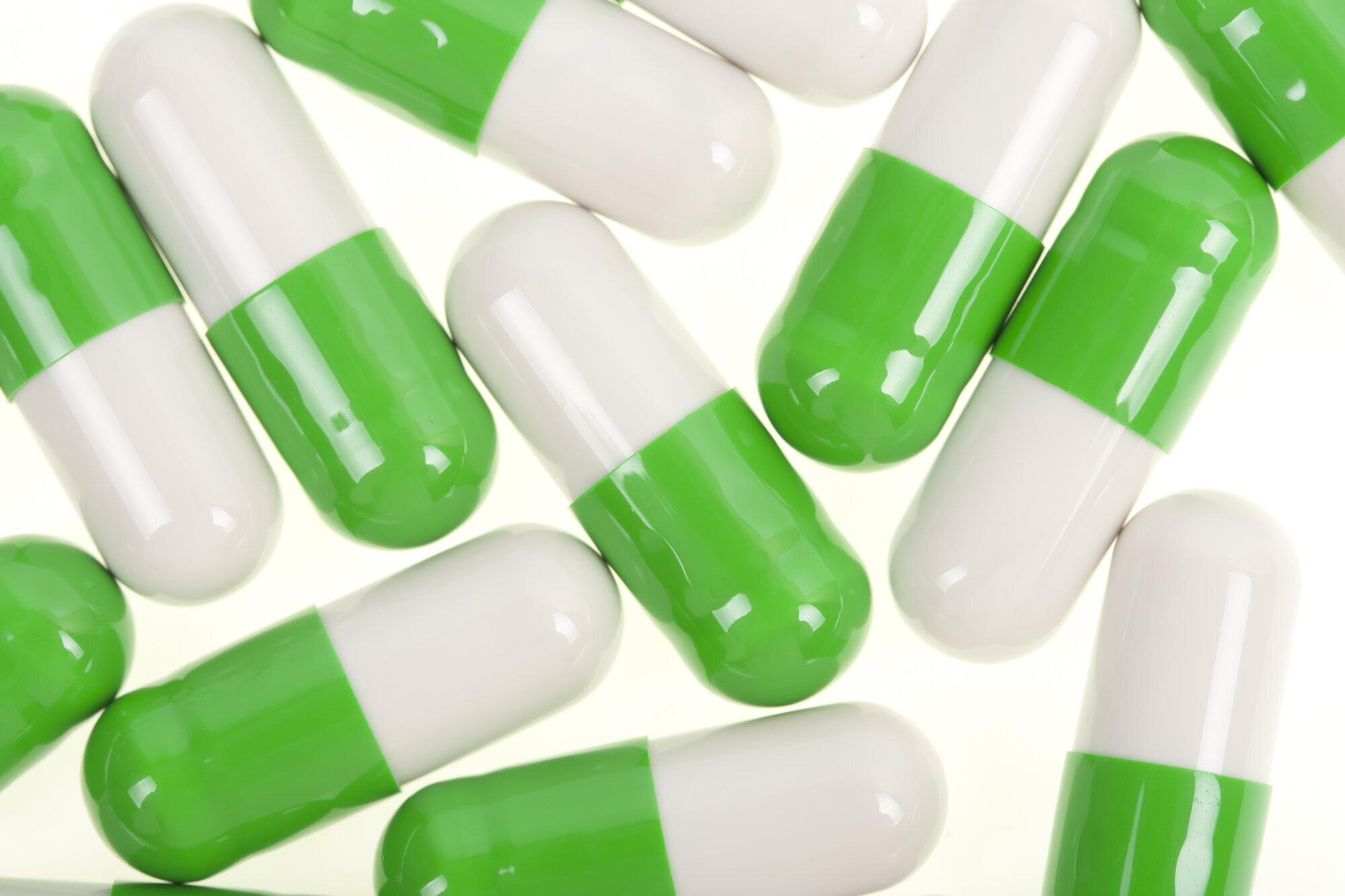 legemidler, illustrasjon Bildet viser kapsler som er grønne og hvite.
