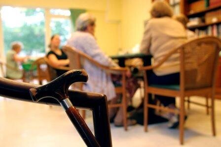 Fire sykehjem i Oslo blir nå helsehus forbeholdt korttidsopphold og rehabilitering. Bildet viser et stokkhåndtak med mennesker ute av fokus i bakgrunnen.