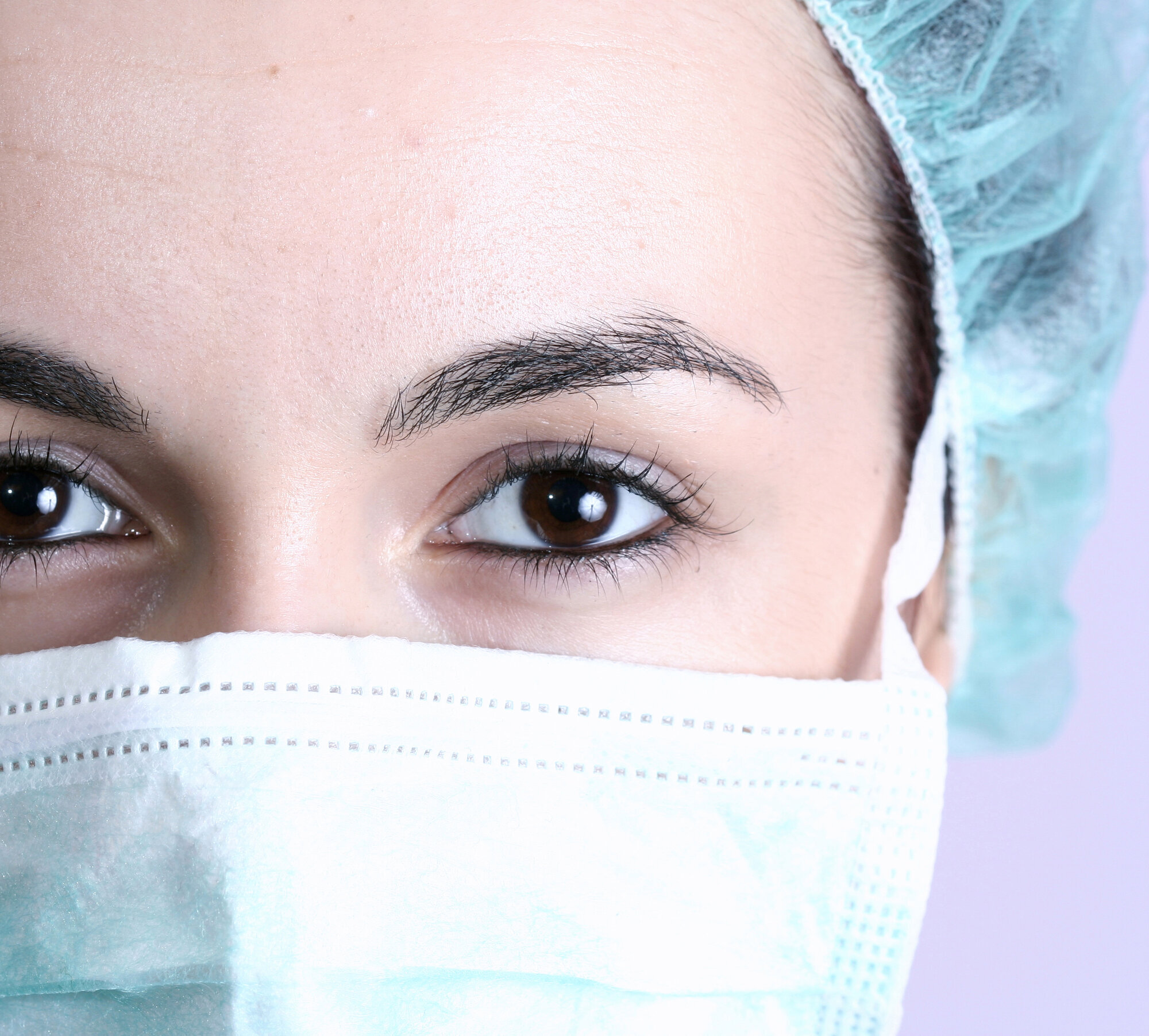 sykepleier, sykepleie Bildet viser portrett av en sykepleier med grønn hette på hodet.