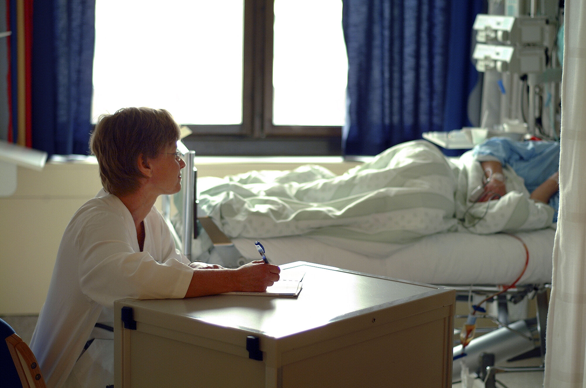Sykepleier skriver dagbok Bildet viser en sykepleier som skriver dagbok for en pasient
