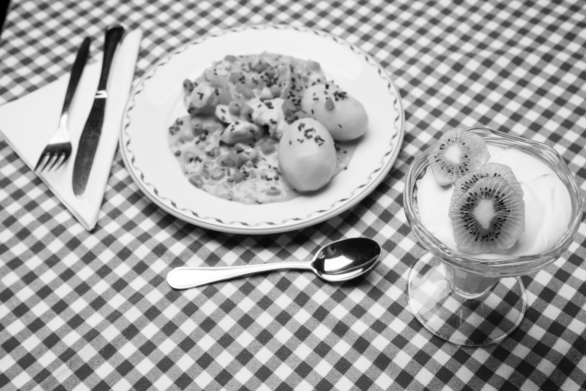 Bildet viser et dekket bord med en tallerken med middag samt ei dessertskål Dekket bord, mat, måltid